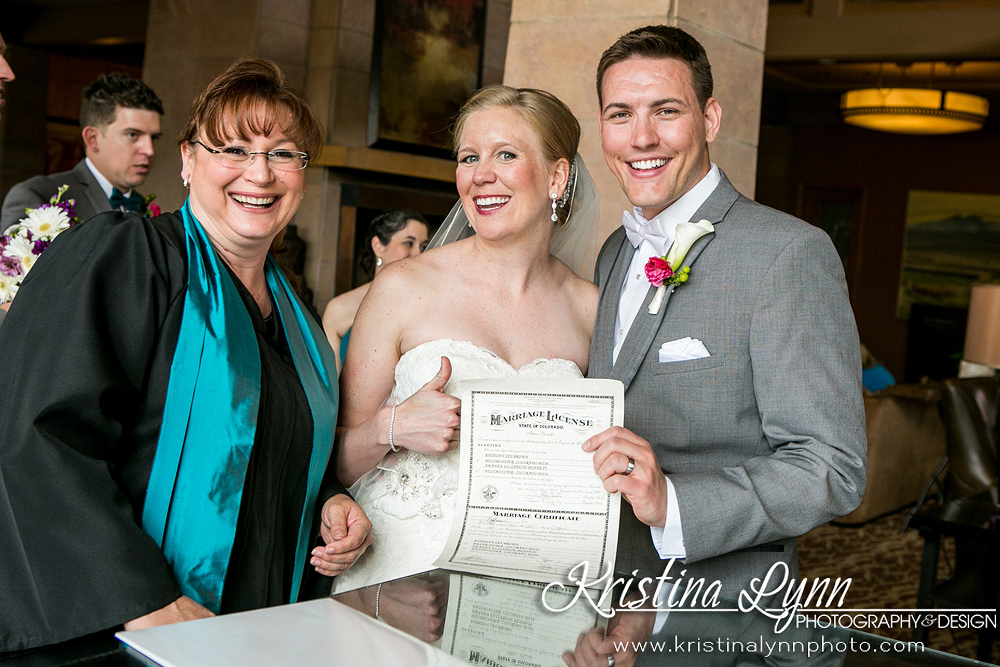 Rev. Kim is standing next to a smiling couple who are holding up their signed marriage licence