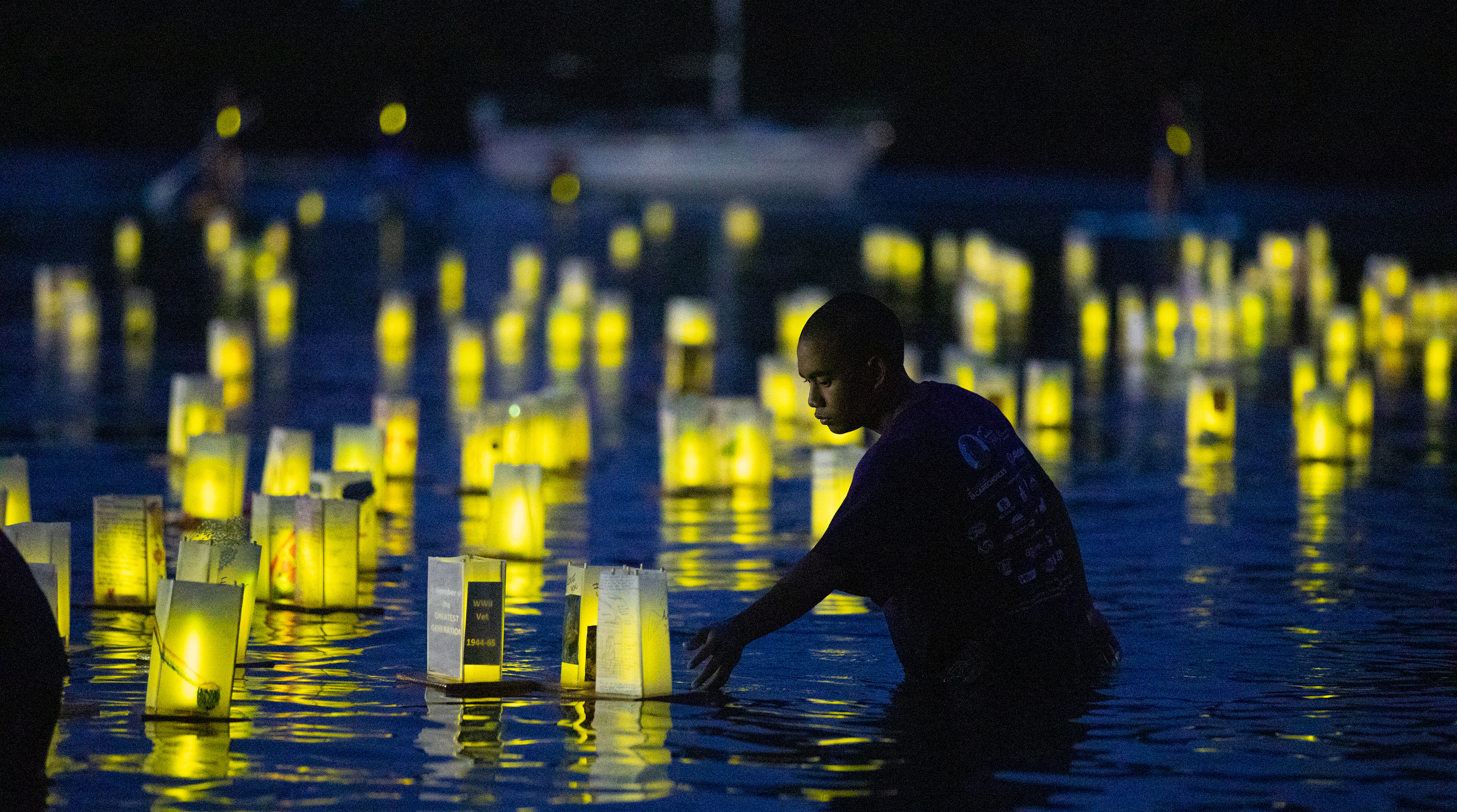 A volunteer from Hawai'i Care Choices leads the lanterns as a group at Reed's Bay, Hilo, Hawai'i, on May 28, 2022.