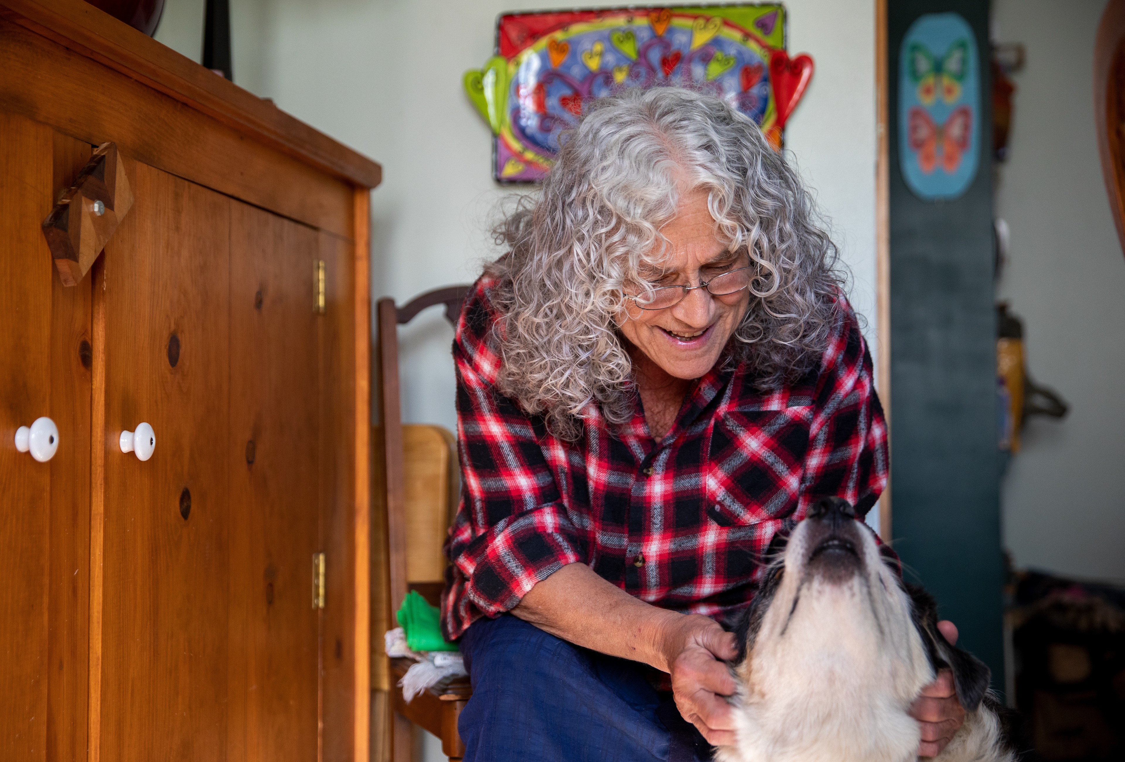 Susan Abramovitz, 71, petting her dog, Sparky, 16, in her home near Rock Riffle Run Pottery on October 10, 2022.