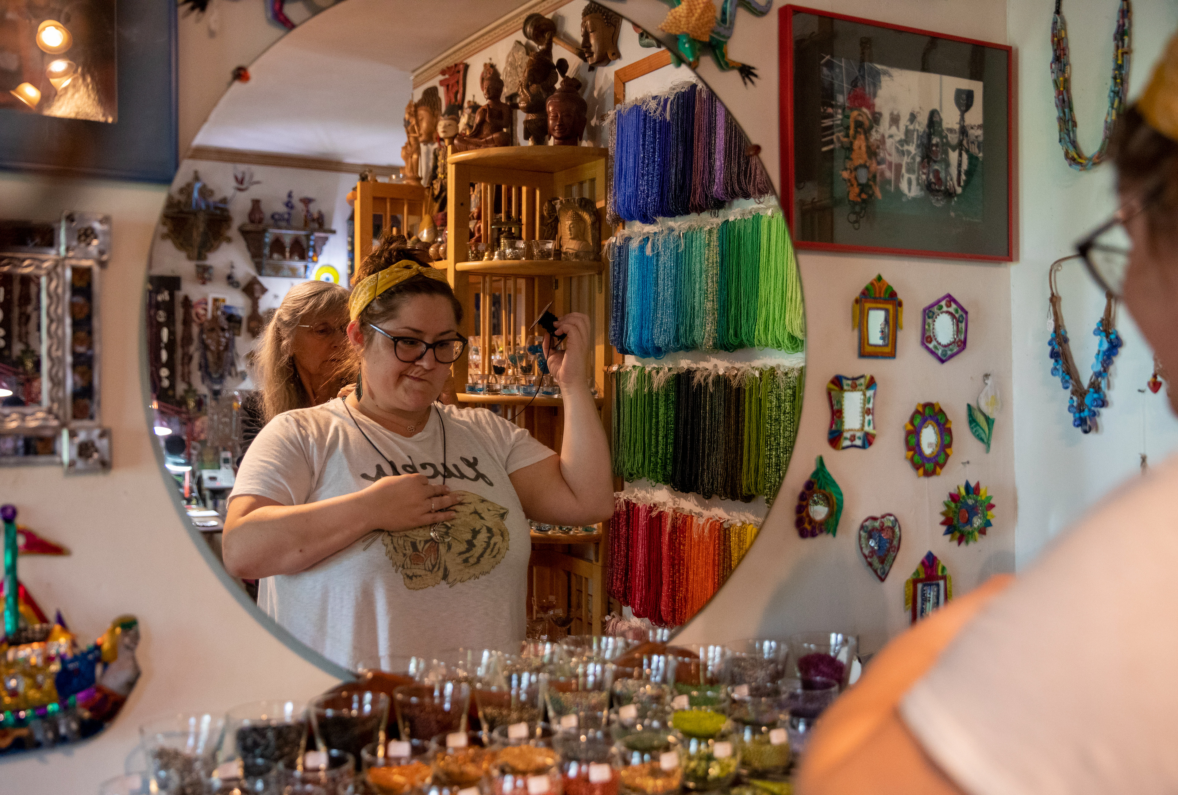 Jo Merkle, 69, helps measure a necklace for Ashley McCunn, 34, to find the right length at Beads and Things, Athens, Ohio on September 9, 2022.