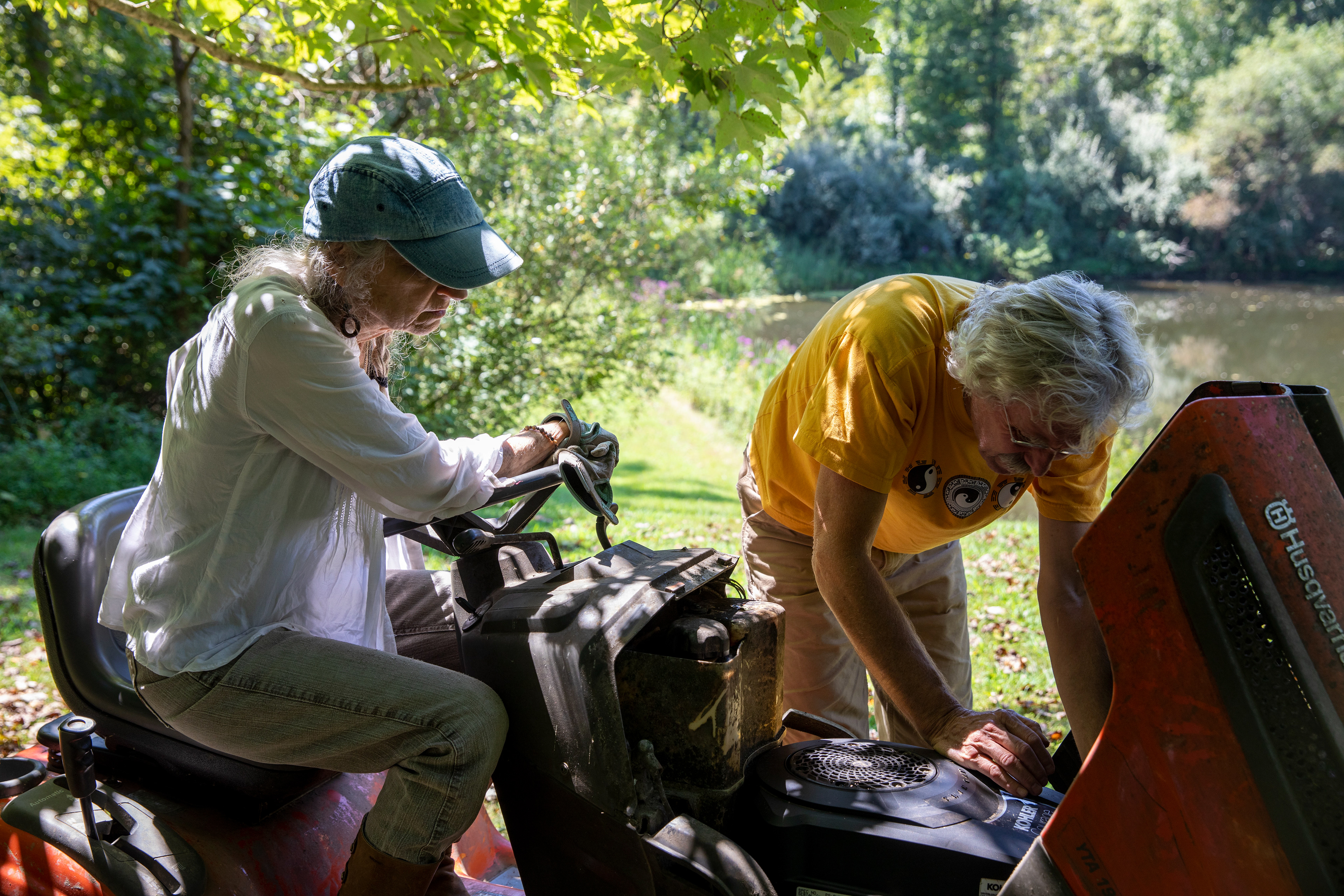 Jo Merkle, 69, and Phil Berry, 67, trying to figure out what is wrong with their lawn mower at their home, in Rome Township, Ohio on August 28, 2022.