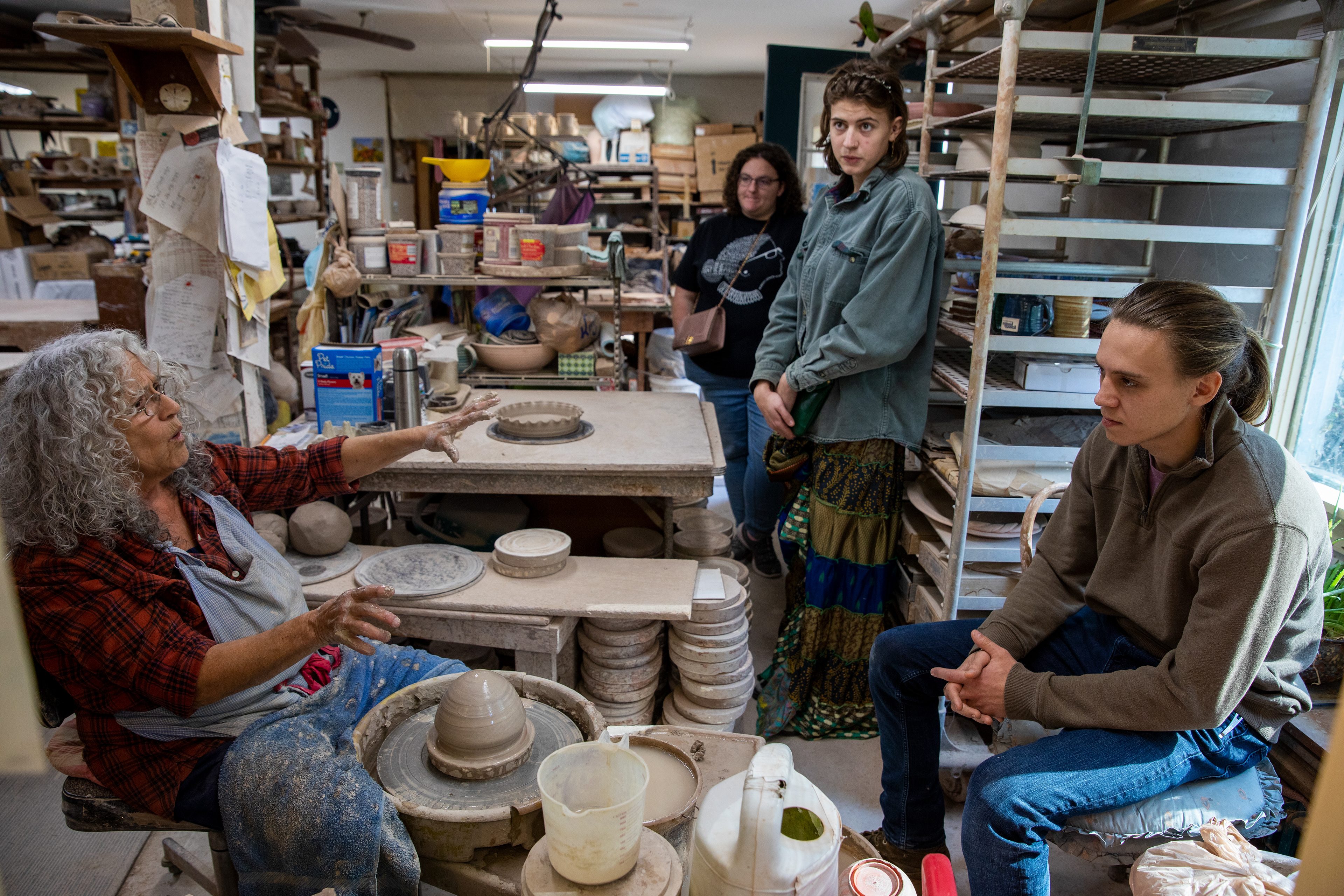 Susan Abramovitz, 71, explaining where she got her clay from natural Appalachian Mountains during a demo to (right to left) Preston Joffe, 23, Elle English,23, and Sarah Solecki, 26, as part of the Rural Action tour group at Rock Riffle Run Pottery on October 22, 2022.