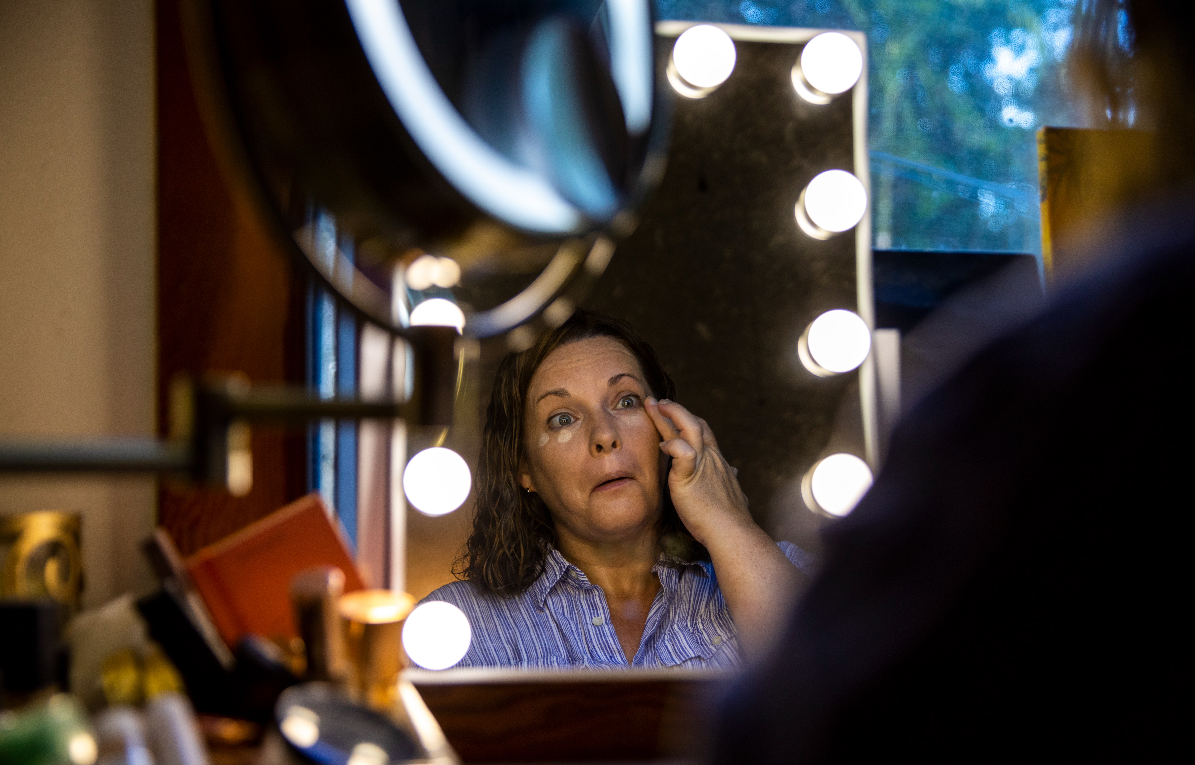 Elizabeth Lawson, 45, applies her makeup at her house in Hawaiian Paradise Park, Hawai'i, on July 27, 2022.