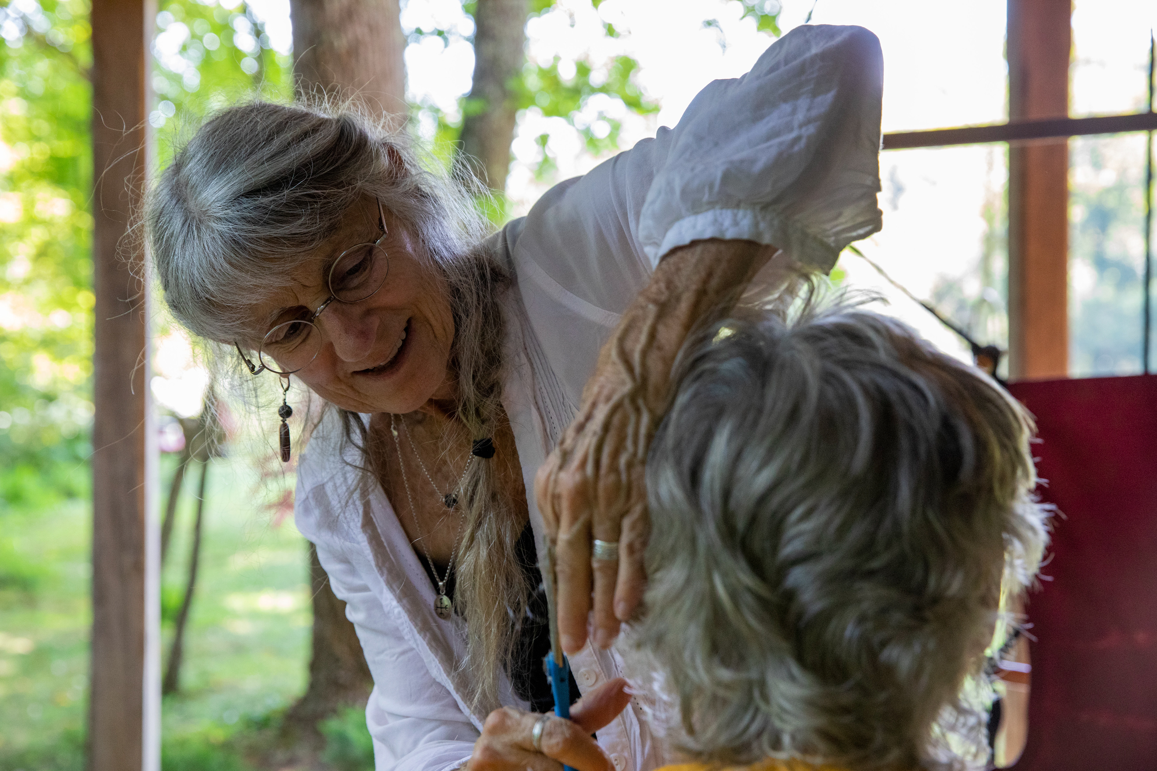 Jo Merkle, 69, trims the hair from Phil Berry, 67, at their home in Rome Township, Ohio on August 28, 2022. Jo likes to call Phil's haircut session her mini art projects.