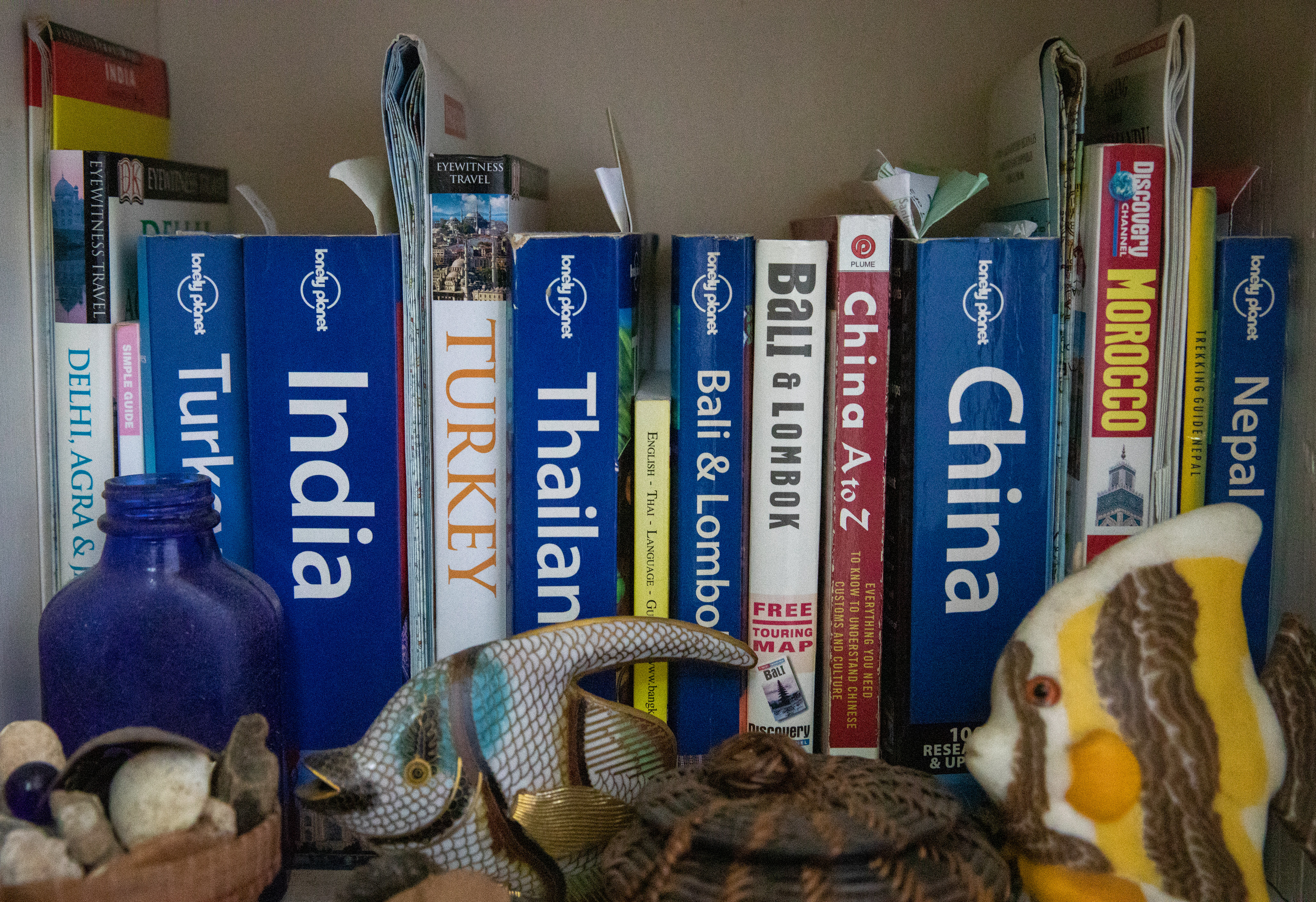 A small collection of travel books and maps that belong to Jo Merkle and Phil Berry from their travels of collecting rocks and memories at their apartment home in Bead and Things, Athens, Ohio on August 29, 2022.