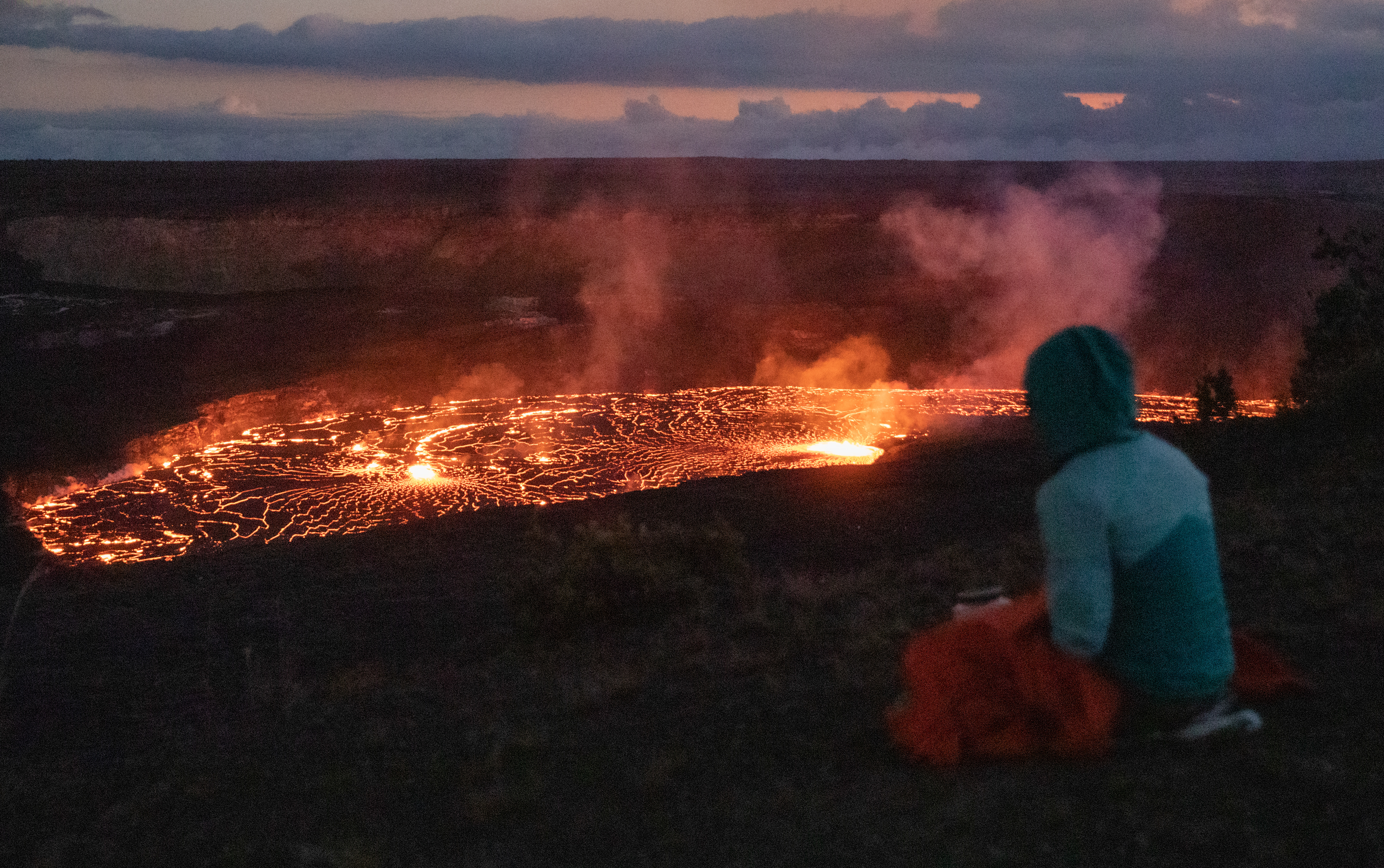 Christina Lieberman, 30, watches the eruption in Halema'uma'u crater from the Kilauea Overlook, Hawaii Volcanoes National Park, on Jan. 5, 2023.