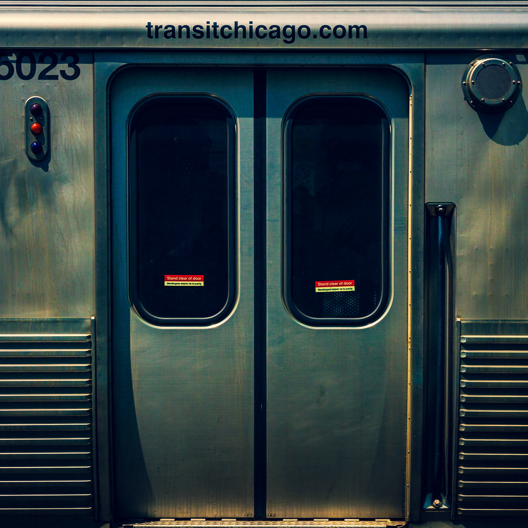 Chicago Transit Authority "el" (elevated) train doors at midday. I've always love the grab bar to the side of the doors; it makes me think that in a movie, someone might swing from it in the breeze at speed, singing.