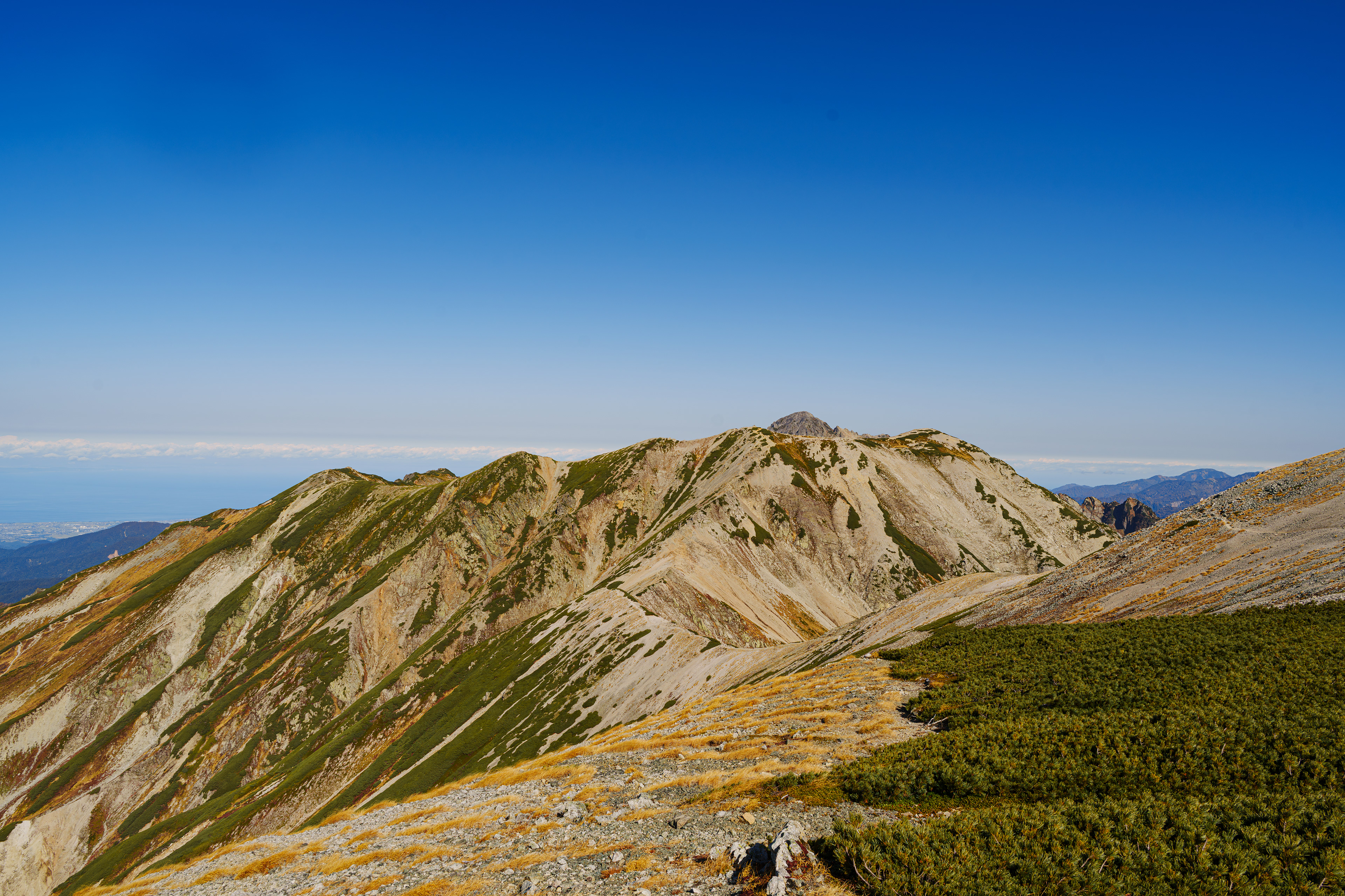 雲一つない晴天の稜線を歩いた。大汝山、富士の折立、真砂岳。目の前に聳え立つのは別山。  2025/10/23　真砂岳
