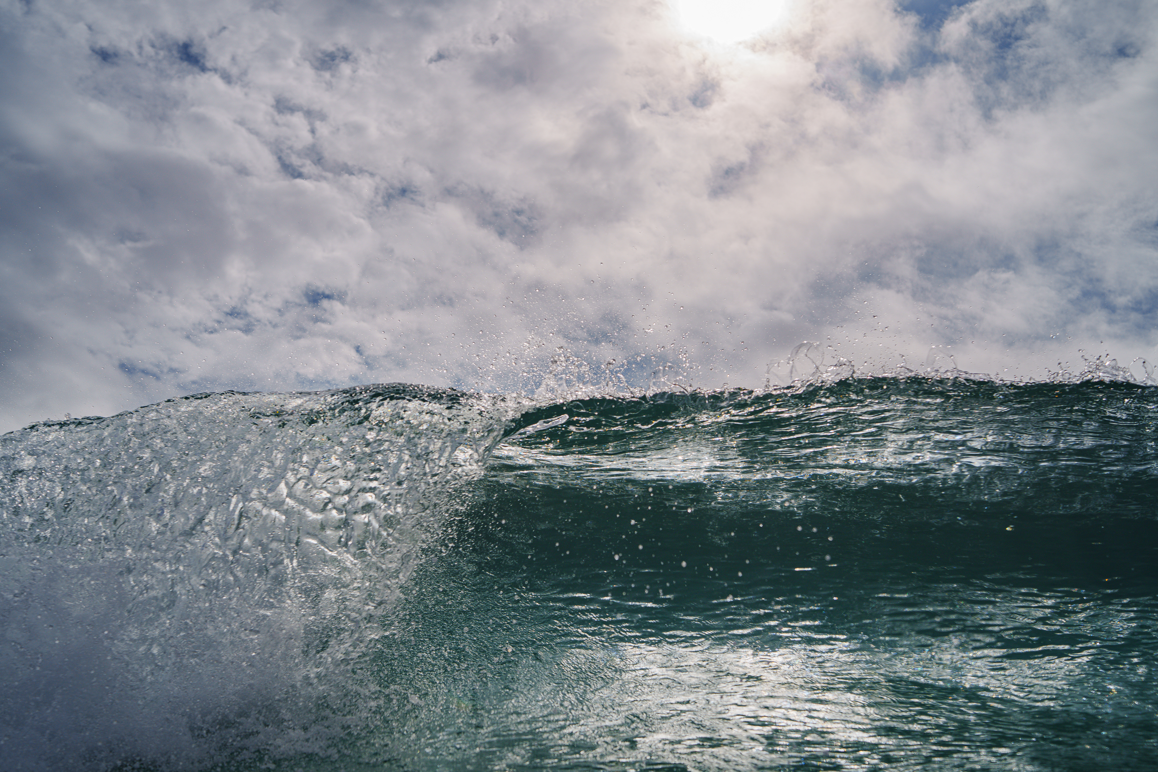 空全体が明るくなり太陽が雲の隙間から顔を出す時間帯があった。セットが来るのを待って、海に背中を着けて浮かぶ格好でカメラを構えてブレイクするギリギリまで我慢をしてシャッターを切った１枚。この波、想像以上にパワーがあり海底まで連れて行かれて叩きつけられた。  06／25\2025 Shikoku