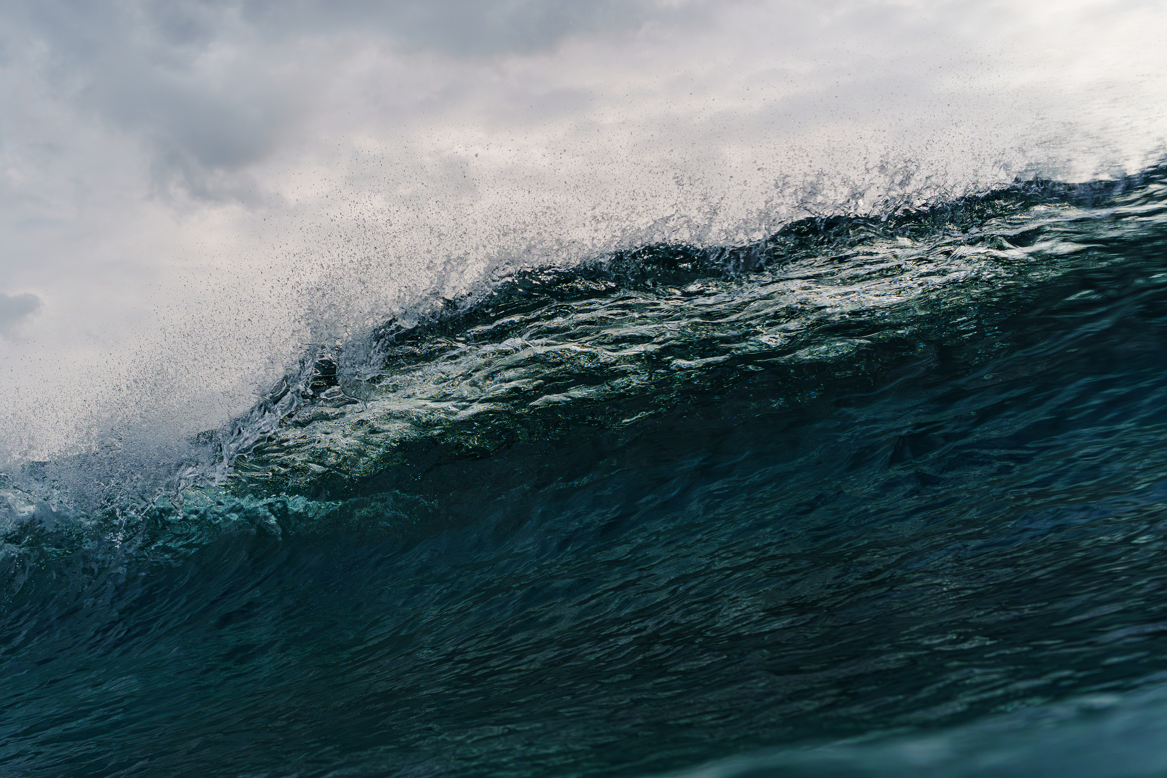 見た目以上にカレントが強くゆっくり波を待ち構えている暇がなかった。シャッターを切って潜ってビーチを見ると流されていた。曇天だったが透明度が高くブレイクする寸前、下に潜り込むとわずかな光が差し込んだ。 2025/10/30　Amami Oshima  (1/1600sec F6.3 ISO800 40mm)