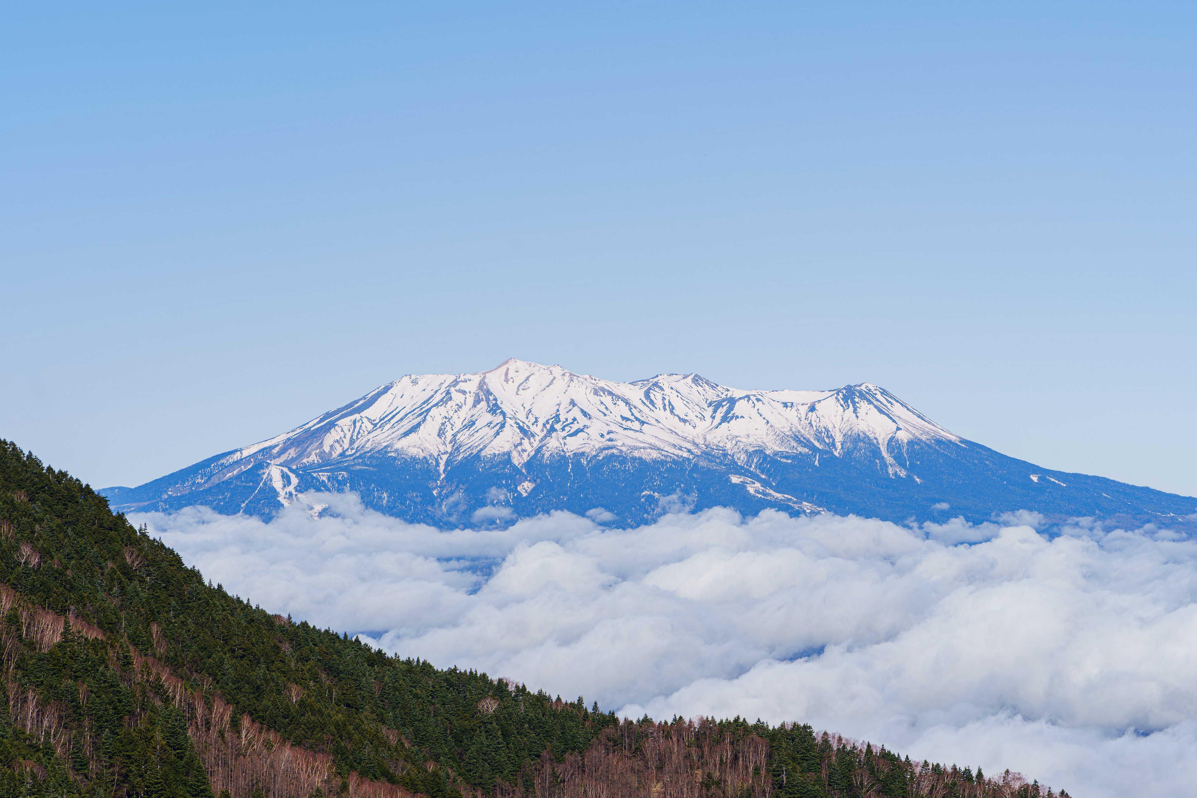 3日目。心配だった天候も回復、雲のない青空が迎えてくれた。今日の目的地は麦草岳。木曽駒ヶ岳を木曽側から登るBルートの途中に分岐があり、そこから山頂を目指す。4合目半から積雪がありズボ足で苦戦しながら標高を上げる。いつもBルートを登る時は天候が悪く、見晴らしの良さそうな場所もガスで真っ白ばかりだけど今日は晴天。昨日見えなかった御嶽山の全貌が見える！ 4/24/2025 Mt.Ontake