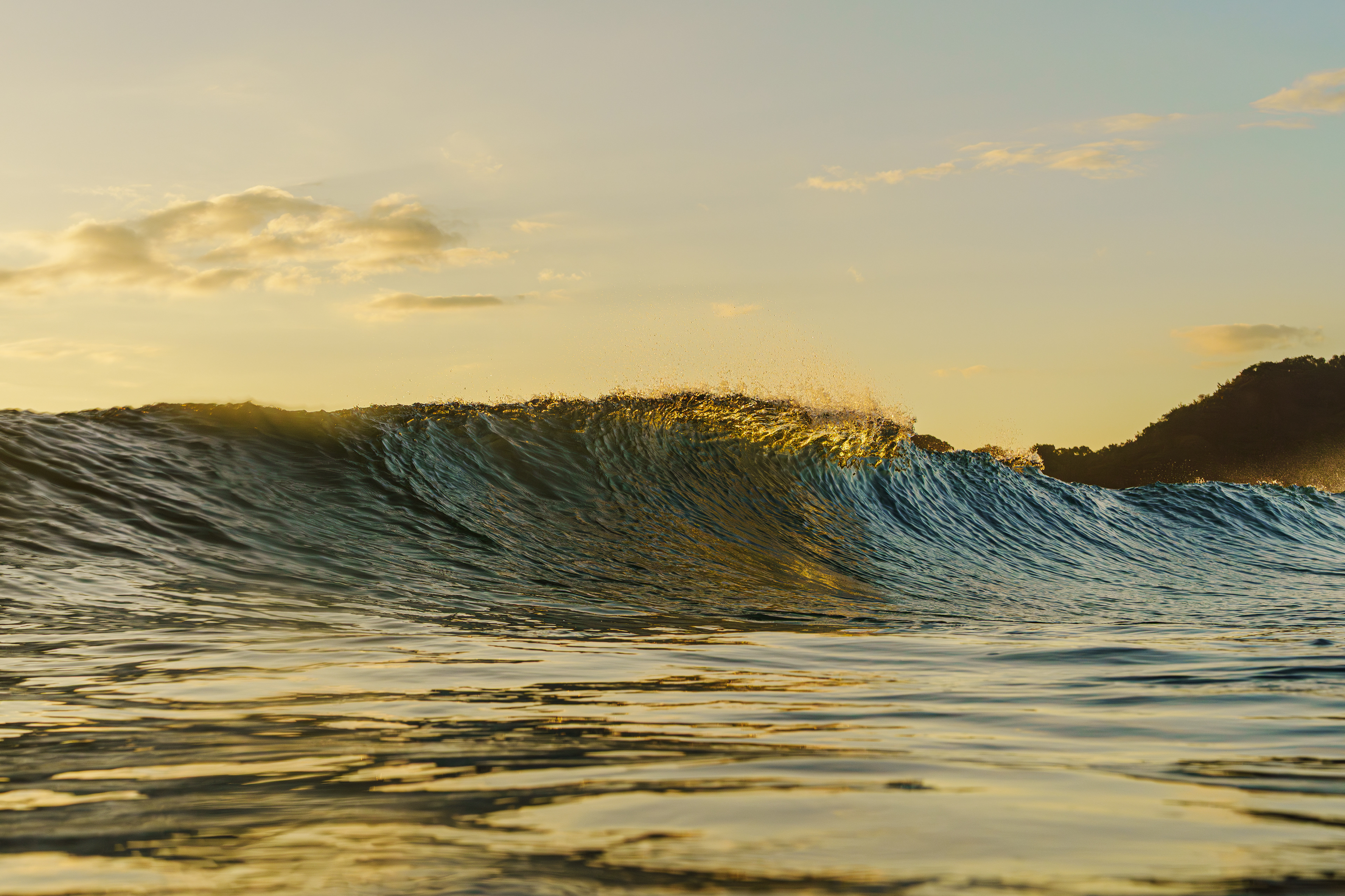 海に着いた時がちょうど干潮で少し潮が動くのを待とうか悩んだが、天気が良く朝陽の時間帯に撮影したかったのですぐに海に入った。波のサイズは腰〜胸で地形も悪くなかった。気温は低かったが水温はまだまだ温かかったので気嵐が発生していた。全体が黄金色に照らされた幻想的な海だった。 2025/11/14　Shikoku (1/1000sec F7.1 ISO800 40mm)