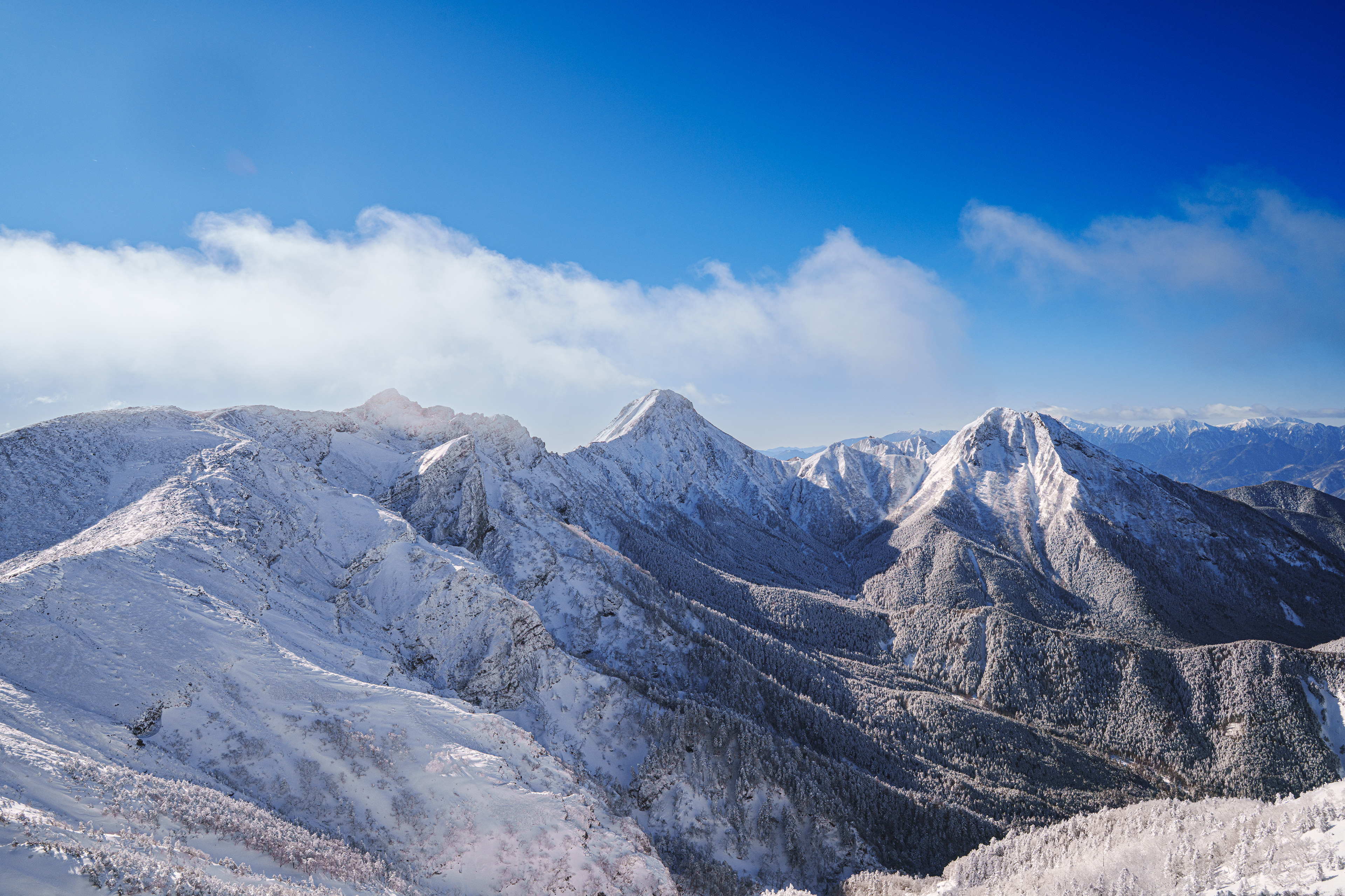 『transform 』 一泊二日で向かった八ヶ岳。登り始めると予報とは違い曇天で山々にはガスがかかっていた。予定では初日に硫黄岳まで登る予定だったが赤岳鉱泉でテントを設営し中山峠まで散歩した。天候回復を期待し翌日早朝から登ることにした。夕方までは風が強かったが、夜になると風が止み空には星が輝いていた。4時に起き支度を済ませ5時過ぎから登り始めた。樹林帯はトレースが残っていて歩きやすかったが、森林限界を過ぎるとノートレースで徐々に雪が深くなってきた。陽が昇り始めると昨日とは打って変わって雲一つない晴天。尾根に出ると風が強くなってきた。たまに吹く強風に煽られ滑落しないようにアックスを効かしながら岩場を歩く。無事硫黄岳登頂、意外に山頂は風が穏やかだった。横岳、赤岳、阿弥陀岳が出迎えてくれた。美しい。厳冬期にこの風景を撮影したかった。   2/13/2025　硫黄岳