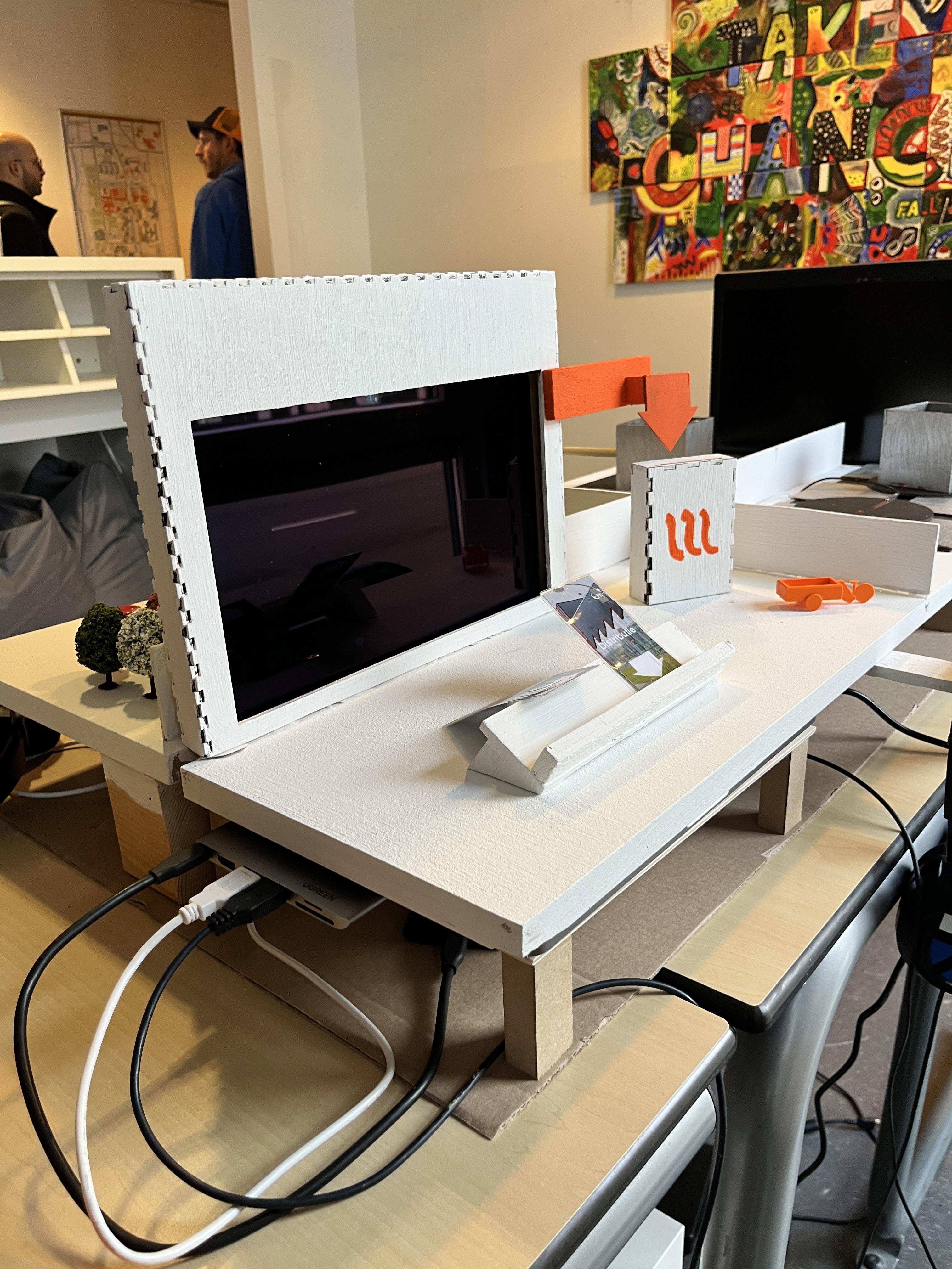 A screen that gives shows explanation videos when a card is put against a card holder, explaining complicated proccesses around the subject of induction stoves.