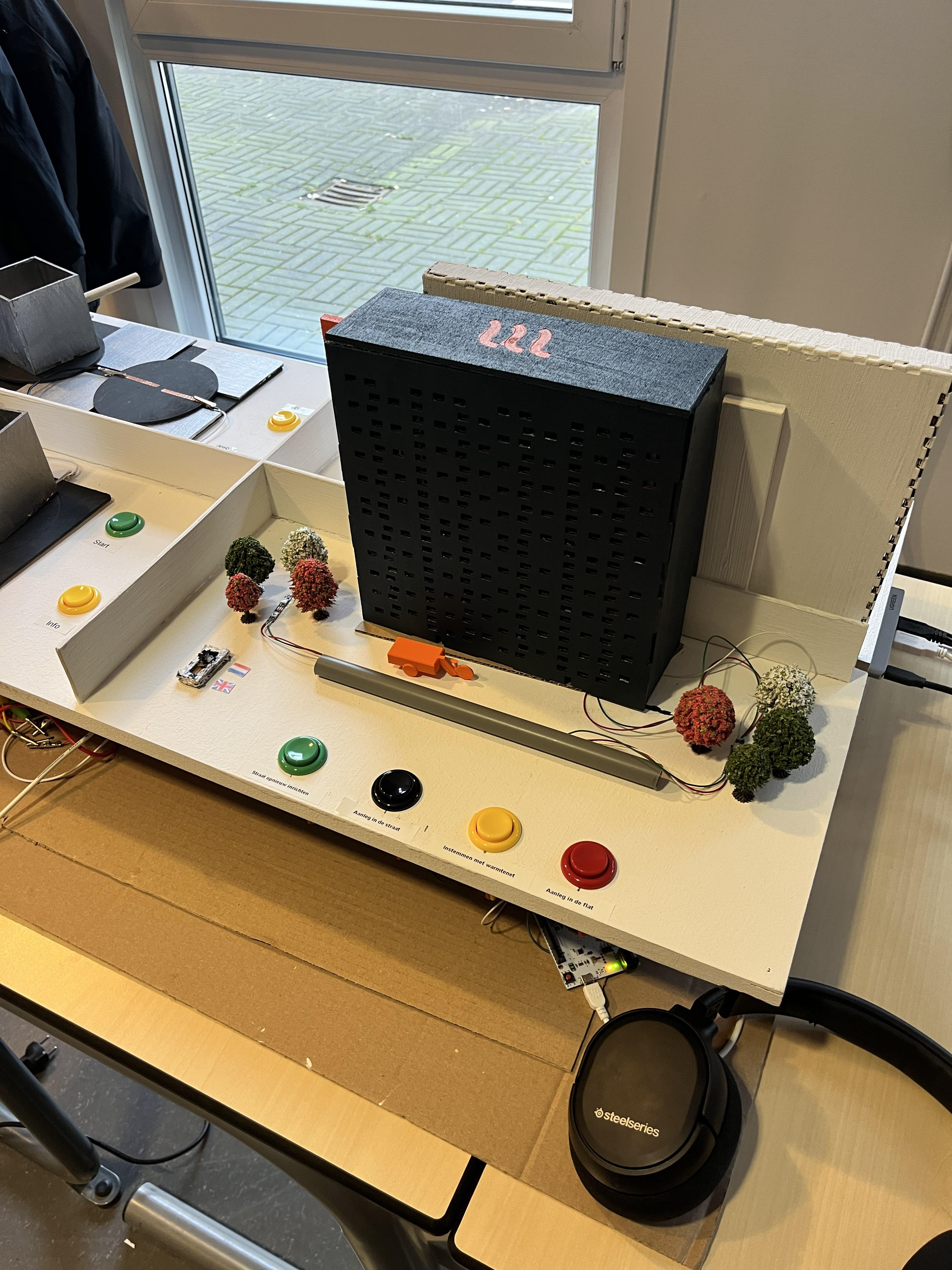 A small scale apartment building that gives explanations of how the procces of  the installation of induction stove works, by pressing the colored buttons.