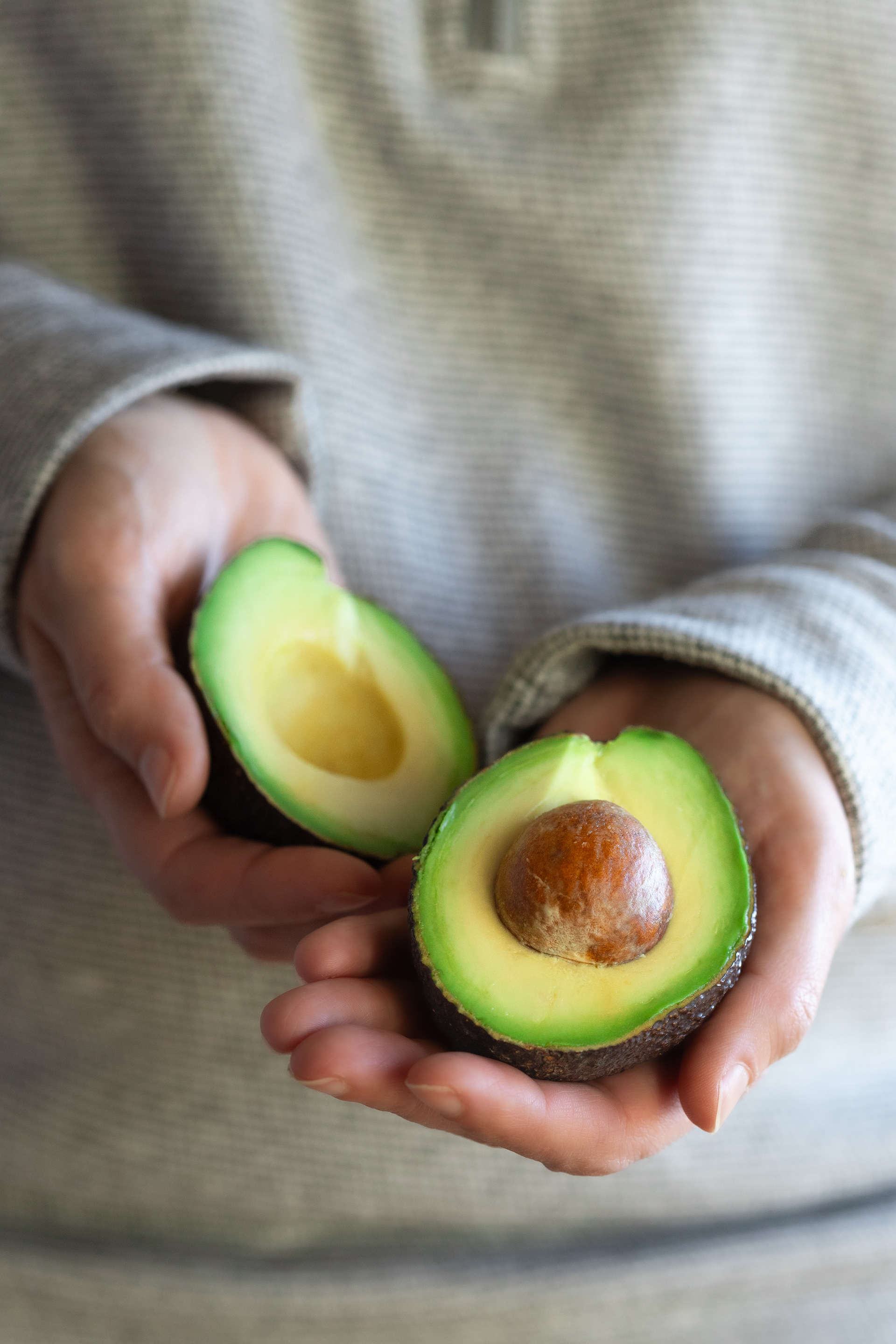 Hands holding guacamole halves