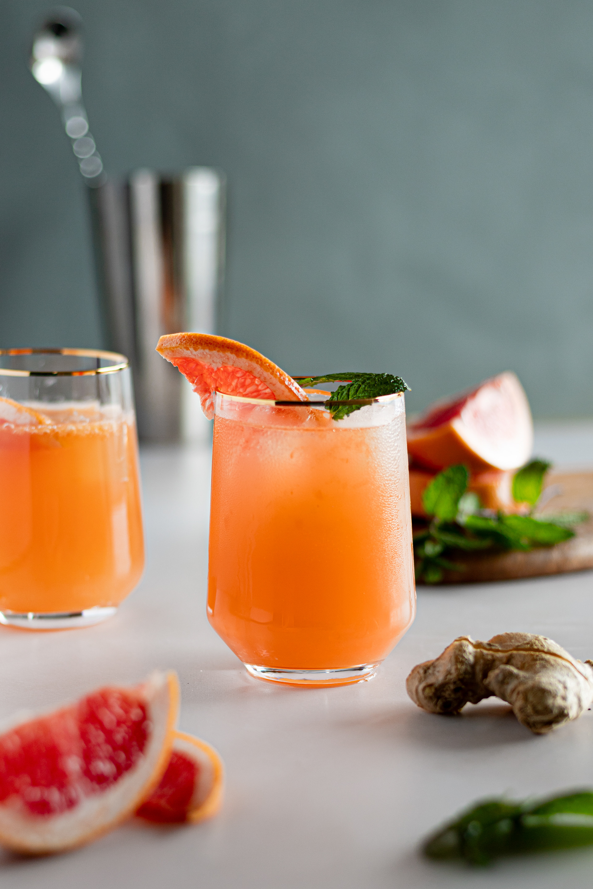 Paloma cocktail with fresh ginger and mint in a clear  glass, beverage photography