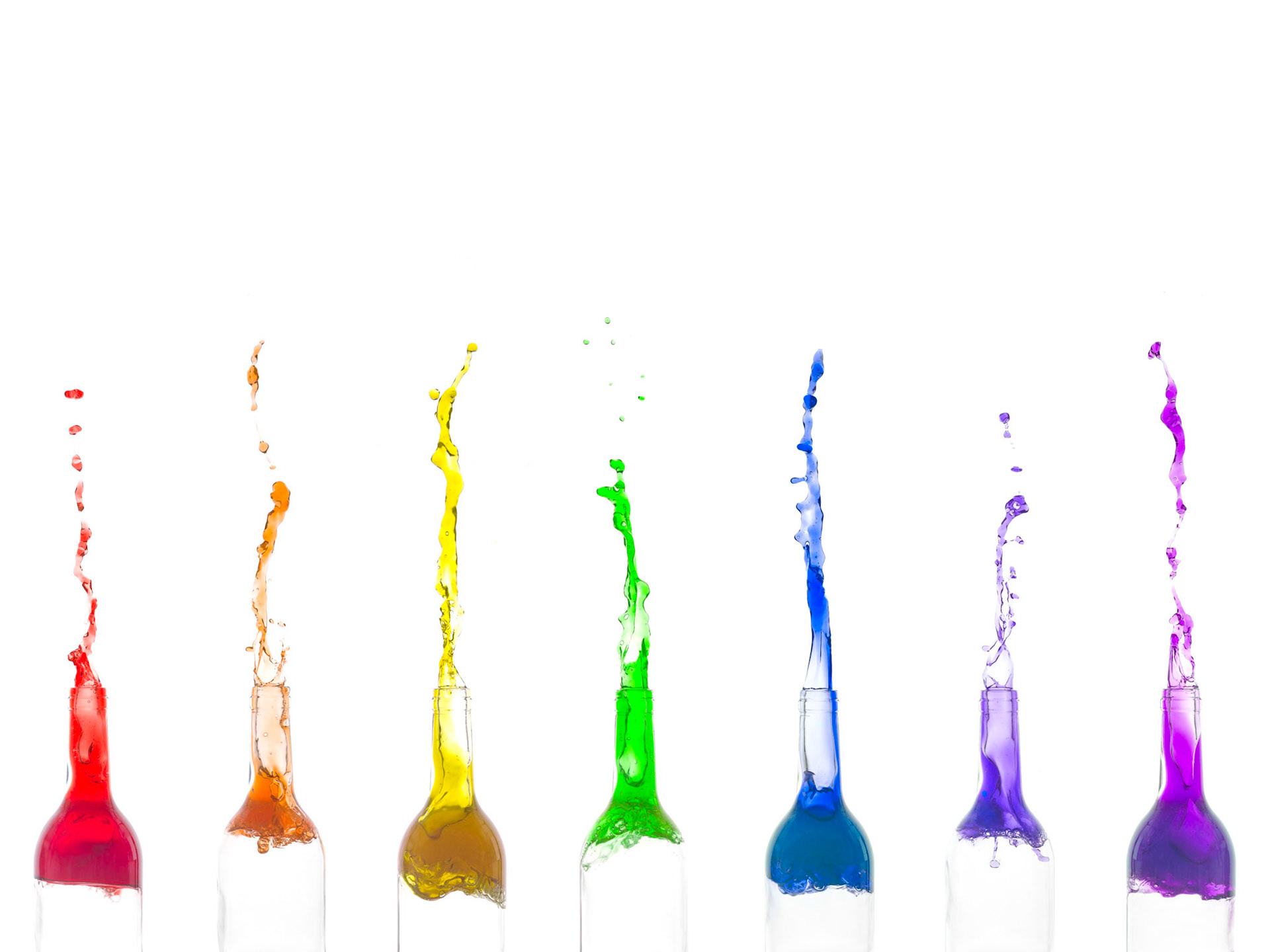 Image of seven bottles with rainbow colour liquid