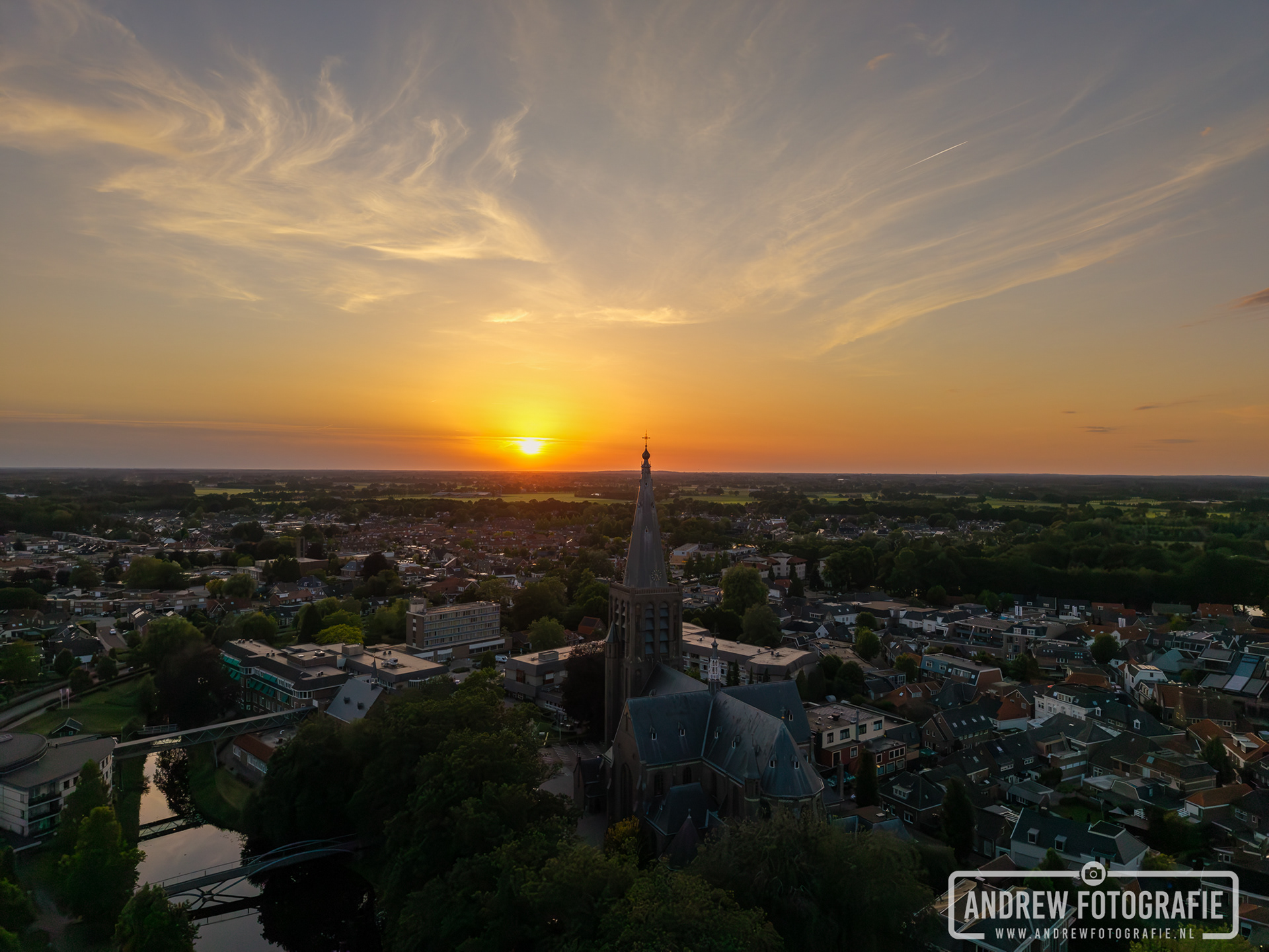 Prachtige dronefoto van de zonsondergang en wolkenlucht boven Groenlo en de Calixtusbasiliek.