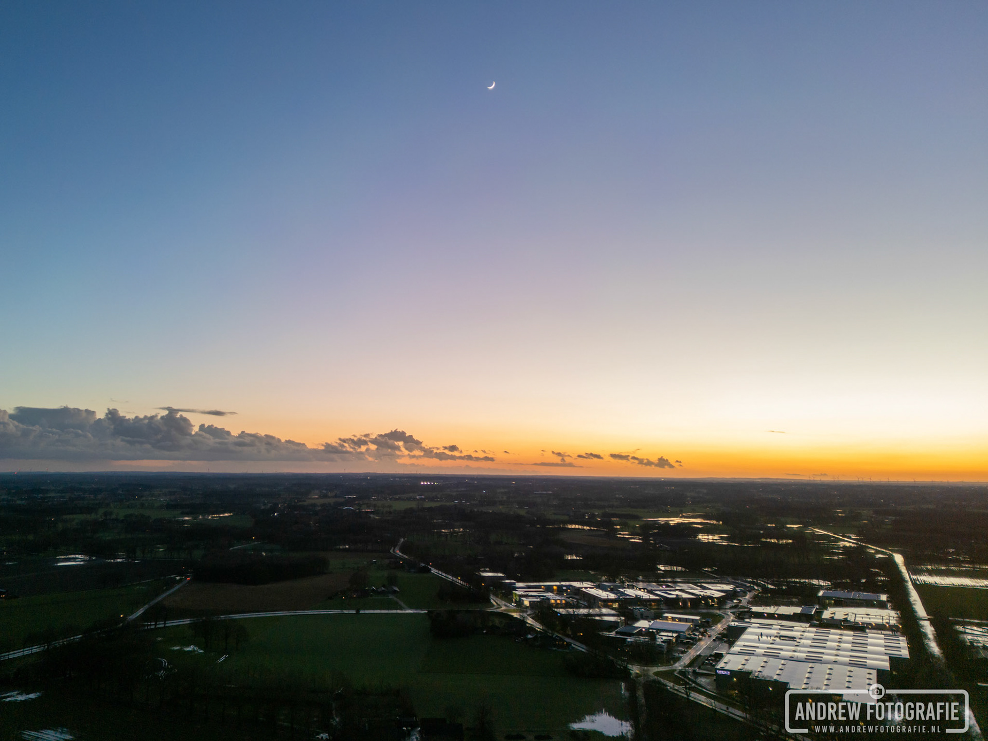 De halve maan is zichtbaar tijdens de zonsondergang in Aalten (12-02-2024).