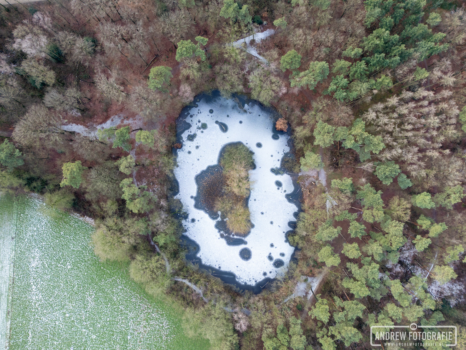 Dronefotografie van het Loohuisbos in Aalten met bevroren vijver vanuit de lucht, abstract winters landschap in de Achterhoek door Andrew Fotografie.