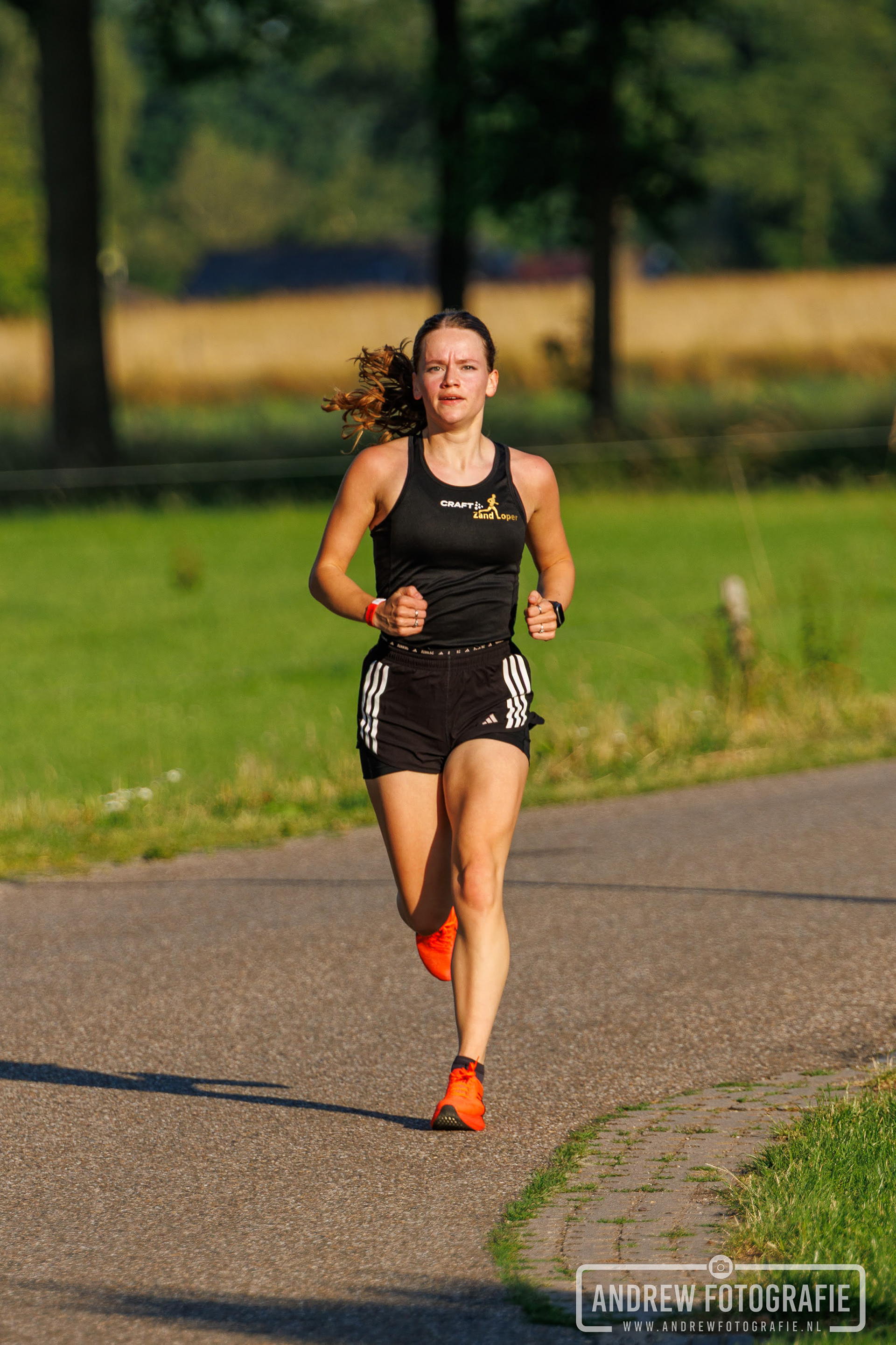 Hardloopster in zwart sportsetje in actie tijdens de Zandloop Lintelo – Andrew Fotografie.