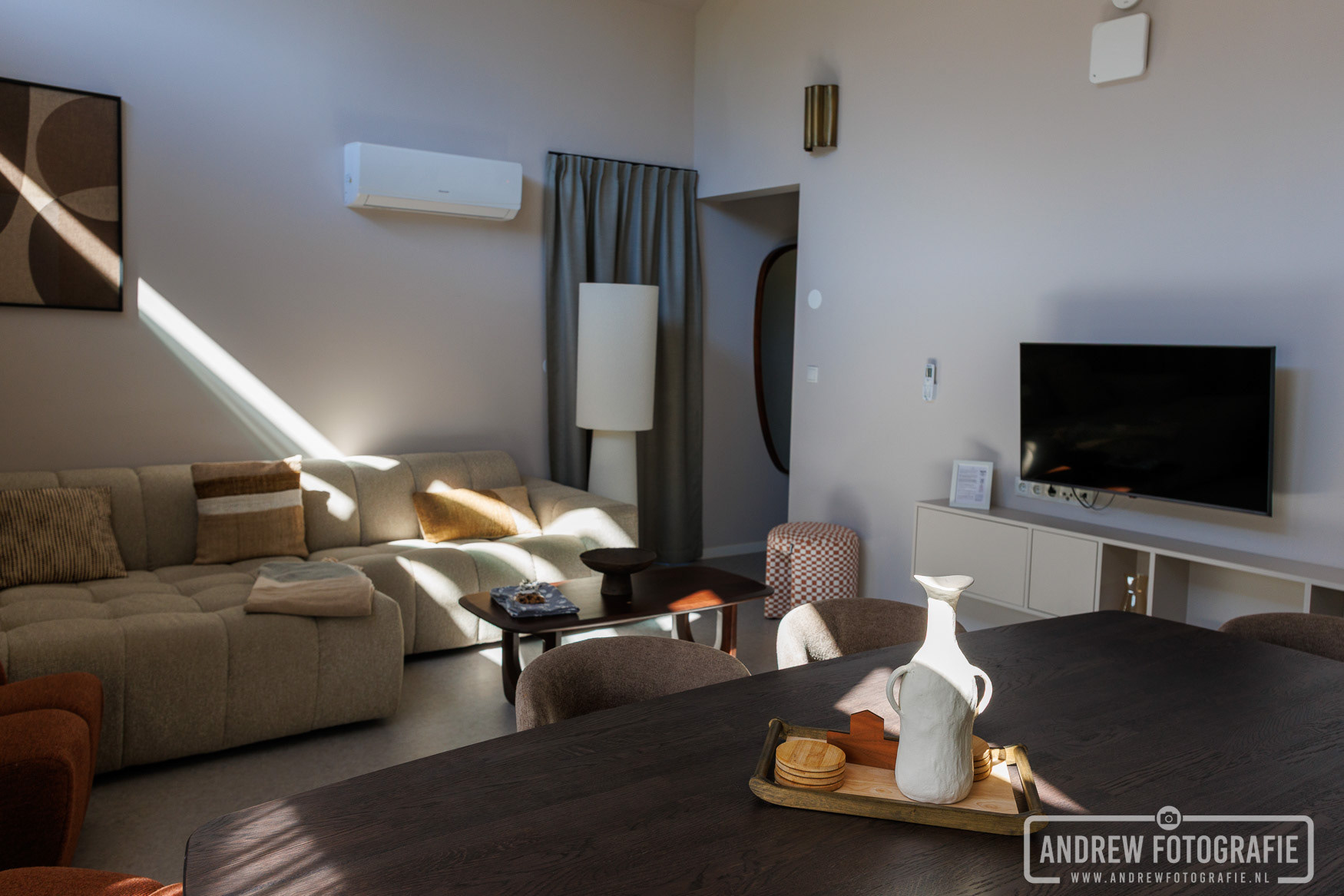 Woonkamer met zithoek, tv en airco in de lodge