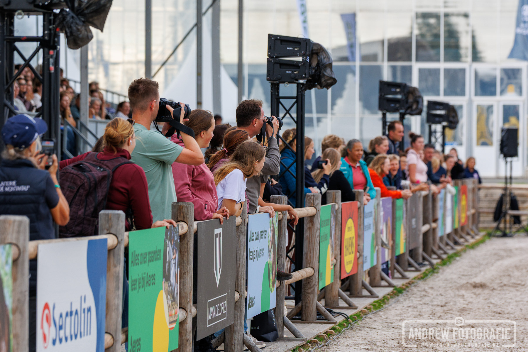 Bezoekers kijken langs de houten omheining naar een demonstratie op Horse Event 2026.