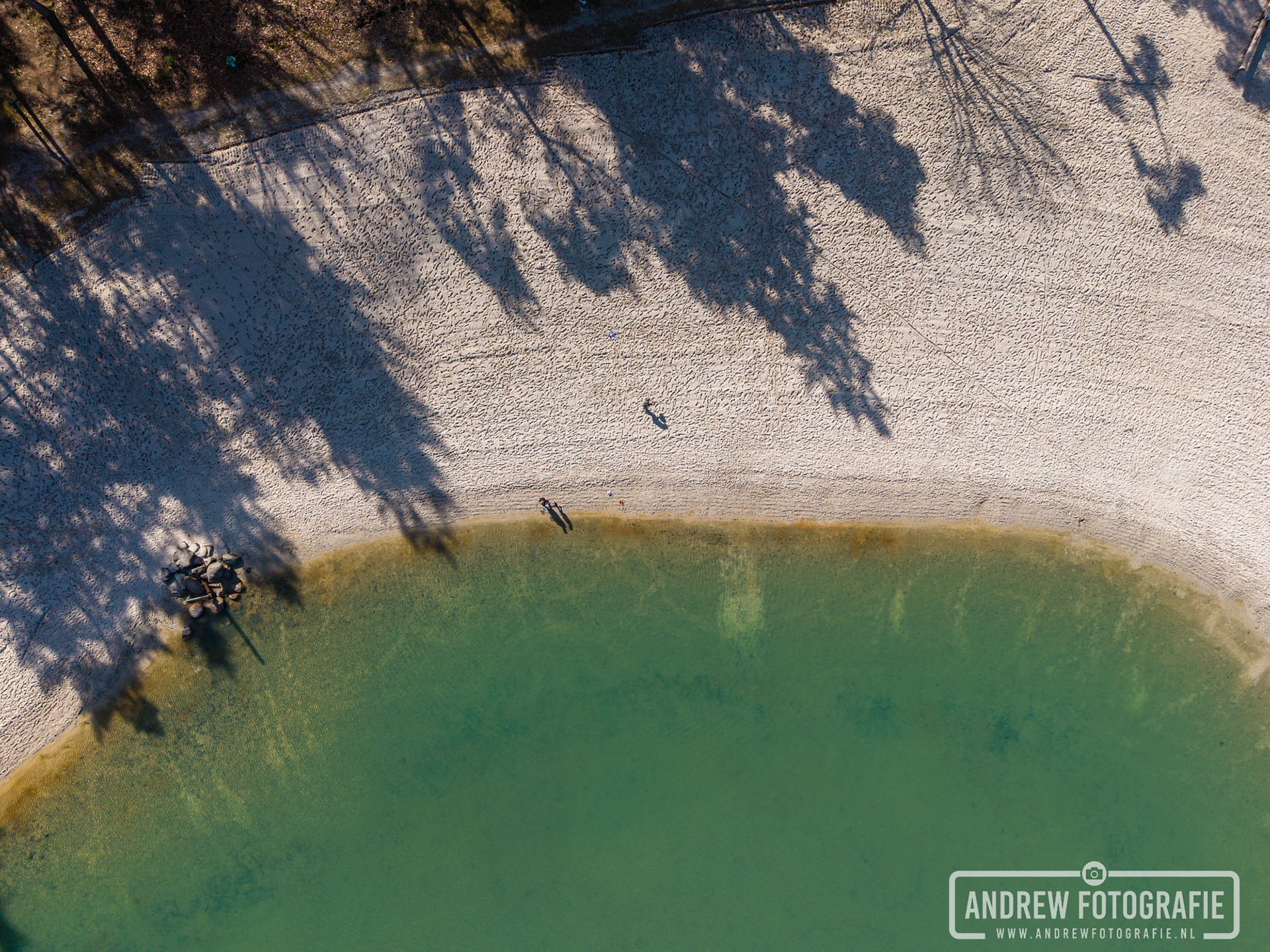 Top-down droneopname van het heldere groenblauwe water en het witte zandstrand in Gasselte