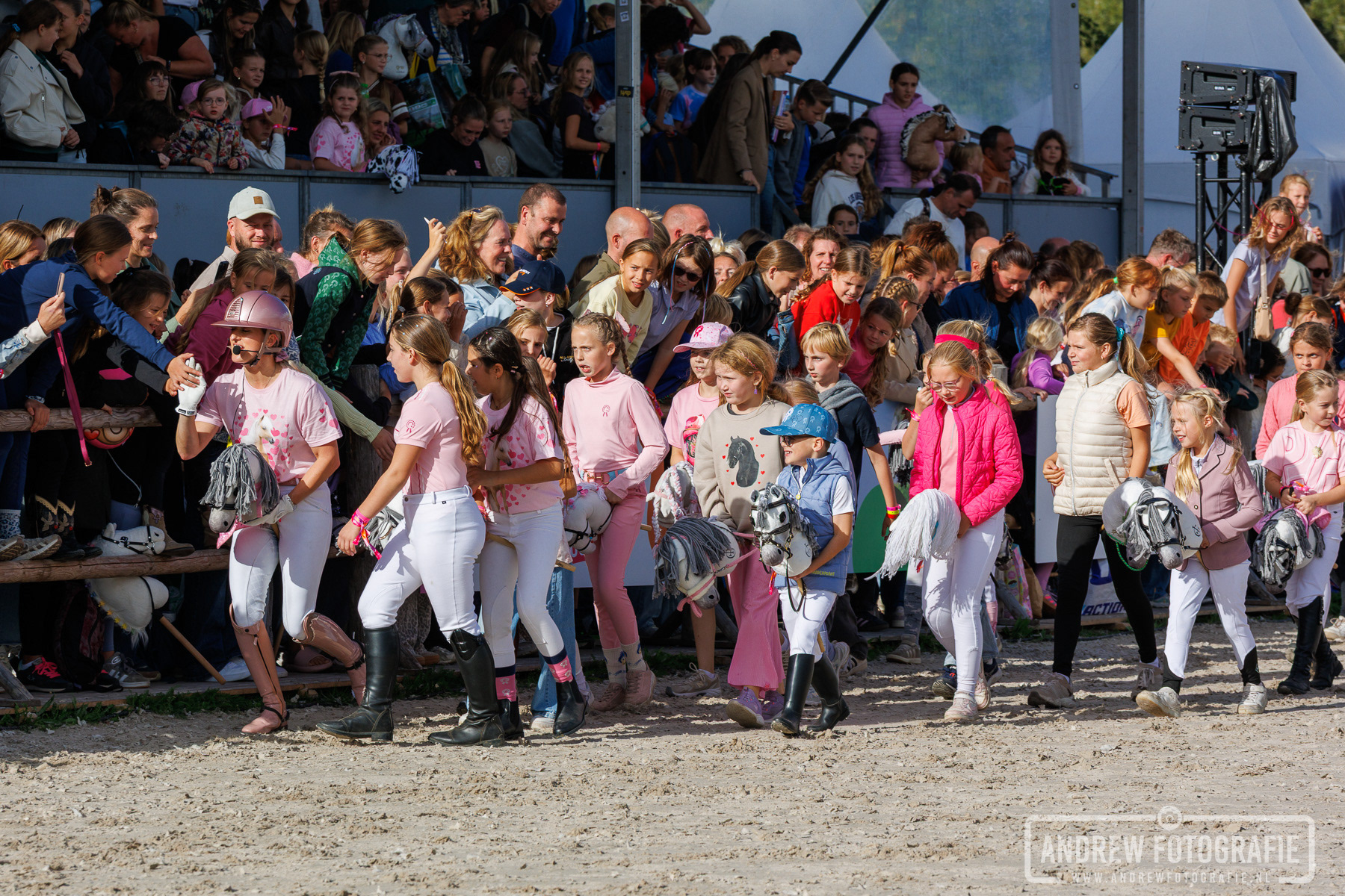 Kinderen paraderen trots met hun stokpaardje door de piste tijdens de George parade op Horse Event Youth