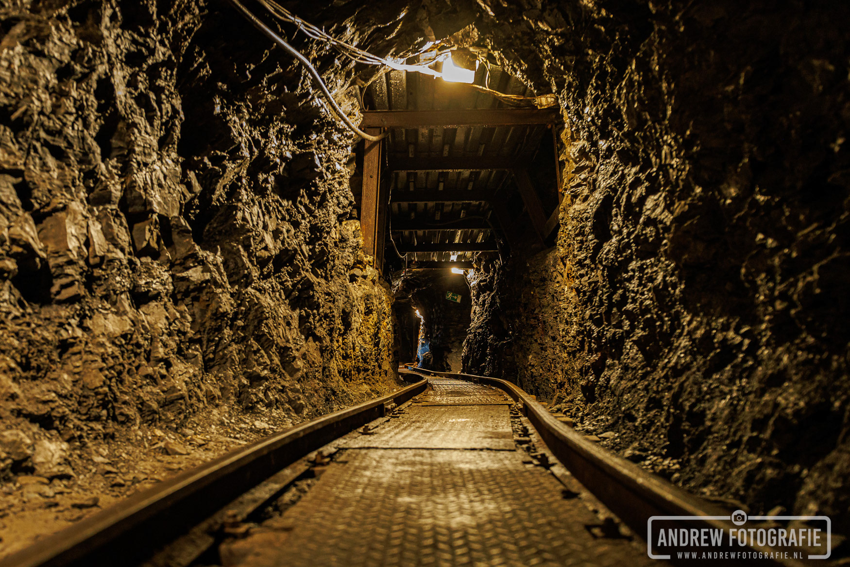 Smalspoor rails in de duistere ondergrondse mijngang van Rabensteiner Stollen Harz