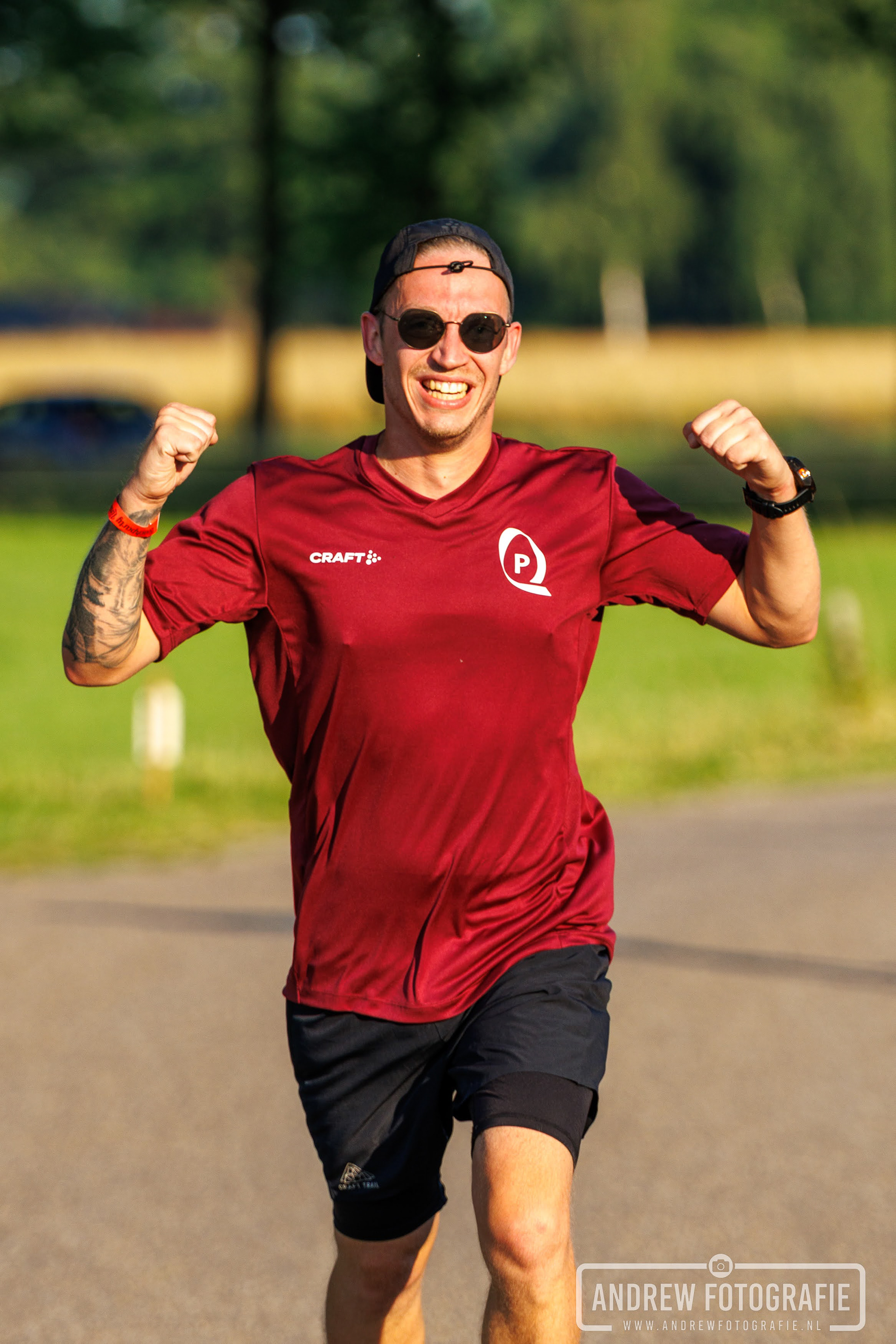 Juichende hardloper in rood shirt tijdens de Zandloop in Lintelo – Andrew Fotografie.