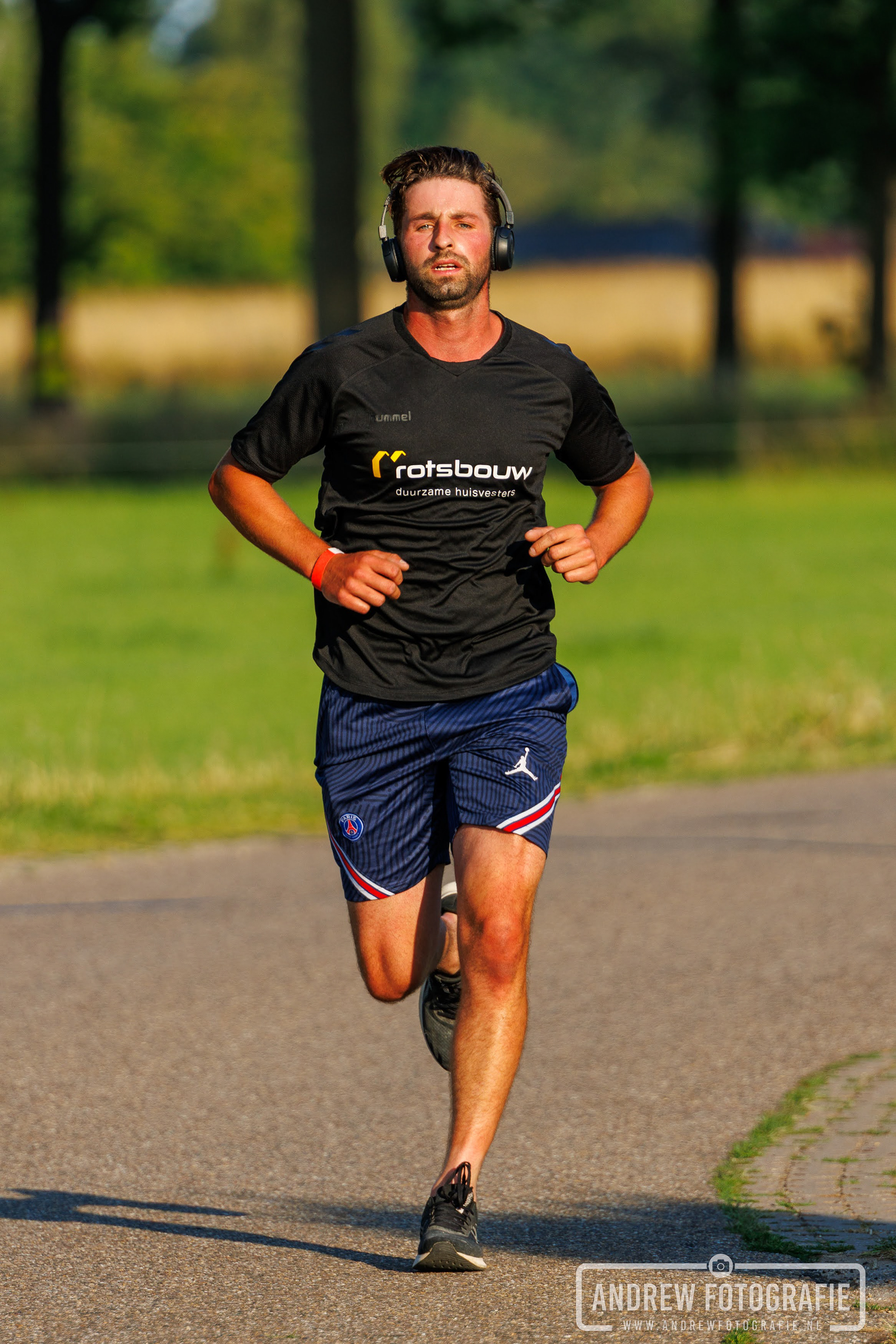 Hardloper in zwart shirt en blauwe short bij de Zandloop in Lintelo – Andrew Fotografie.