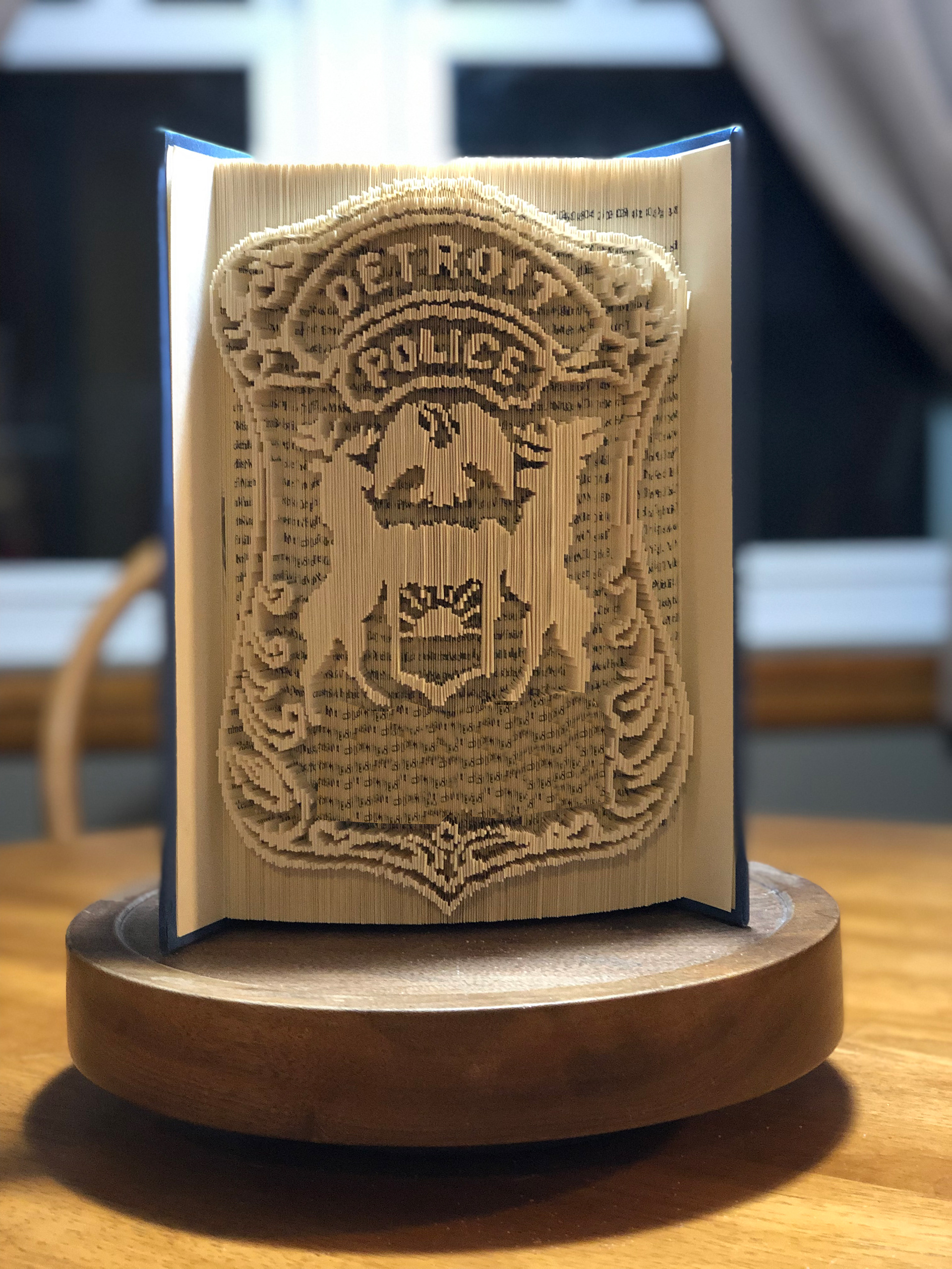A retired police officers badge recreated and folded into a book as a surprise gift. (The badge number was in the design, ubt it blurred out of the photo.)