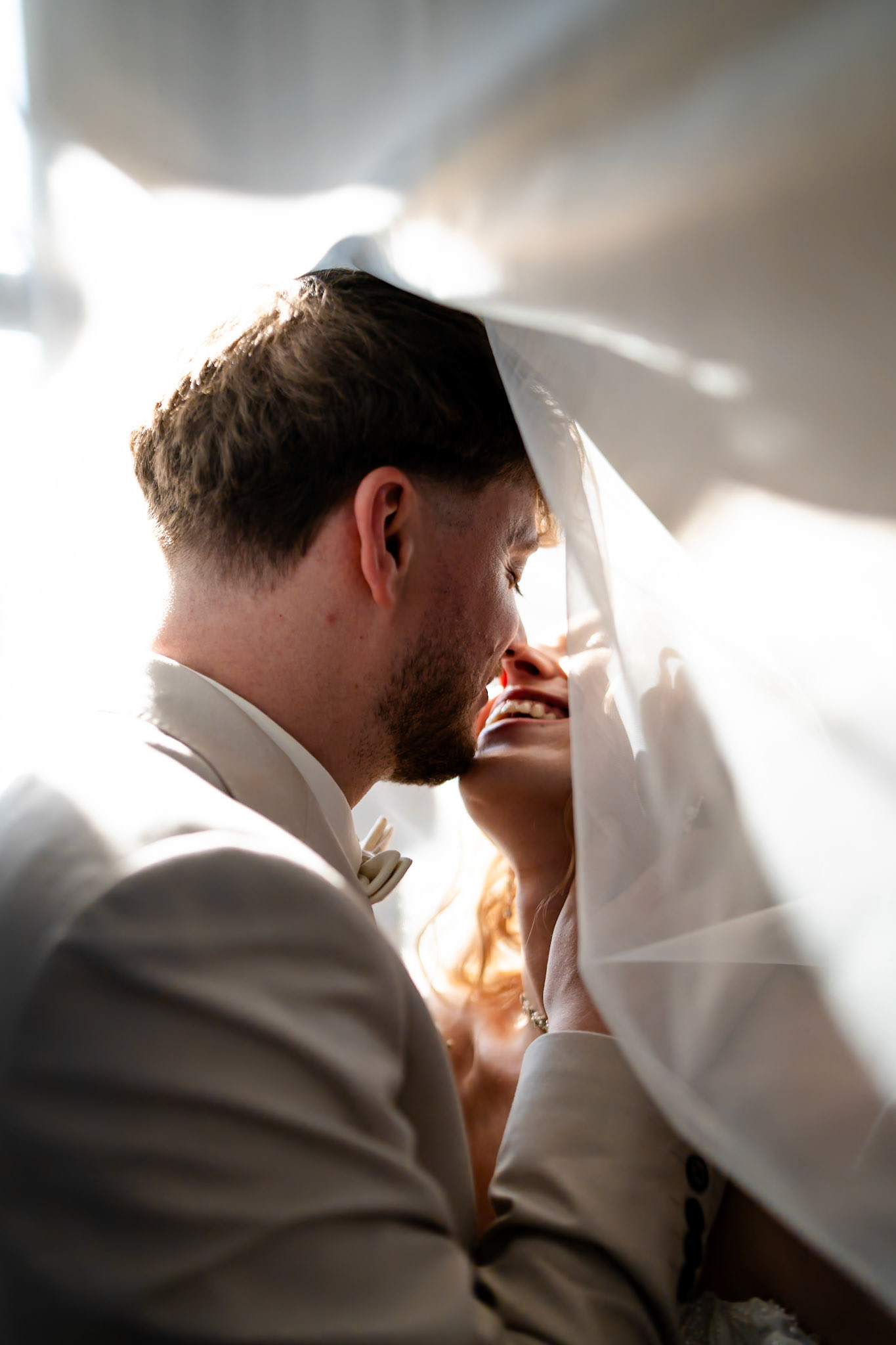 Romantisches Hochzeitsportrait von Braut und Bräutigam unter dem fließenden Brautschleier – MFuchsloch Hochzeitsfotografie & Videografie