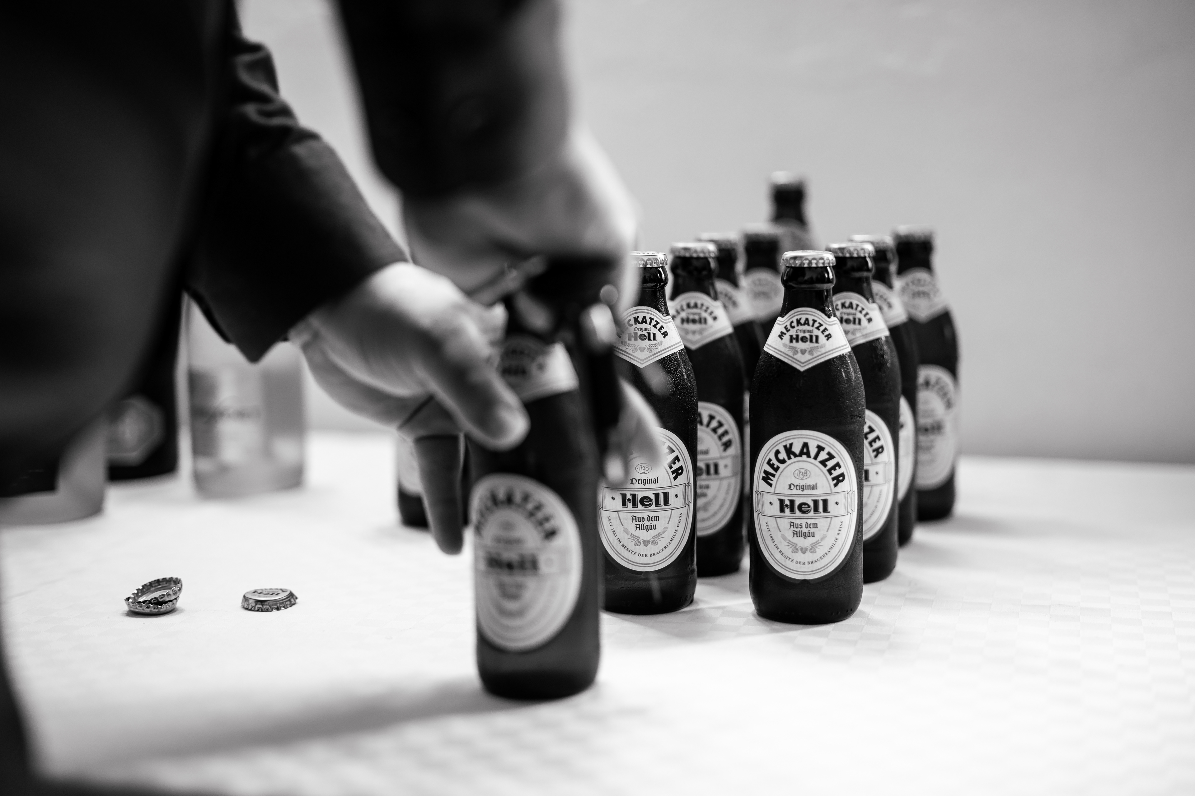 Öffnen eines Meckatzer Bieres beim lockeren Empfang der Hochzeitsgesellschaft. Hochzeitsfotografie Bad Schussenried MFUCHSLOCH.