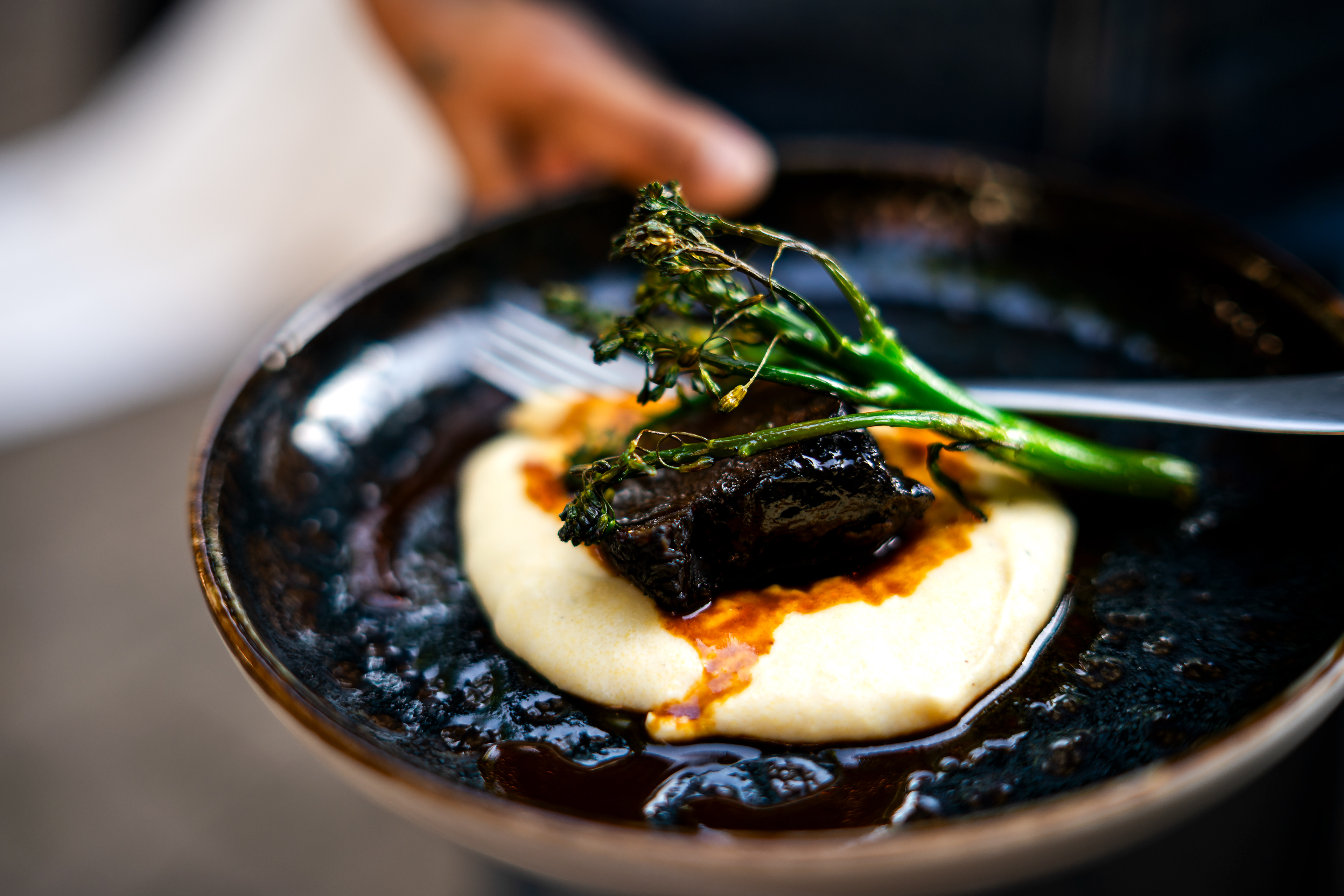 Exquisiter Hauptgang: Geschmortes Fleisch auf Püree mit Brokkoli. Hochwertige Food-Fotografie auf einer Hochzeit von MFUCHSLOCH Fotografie & Videografie.