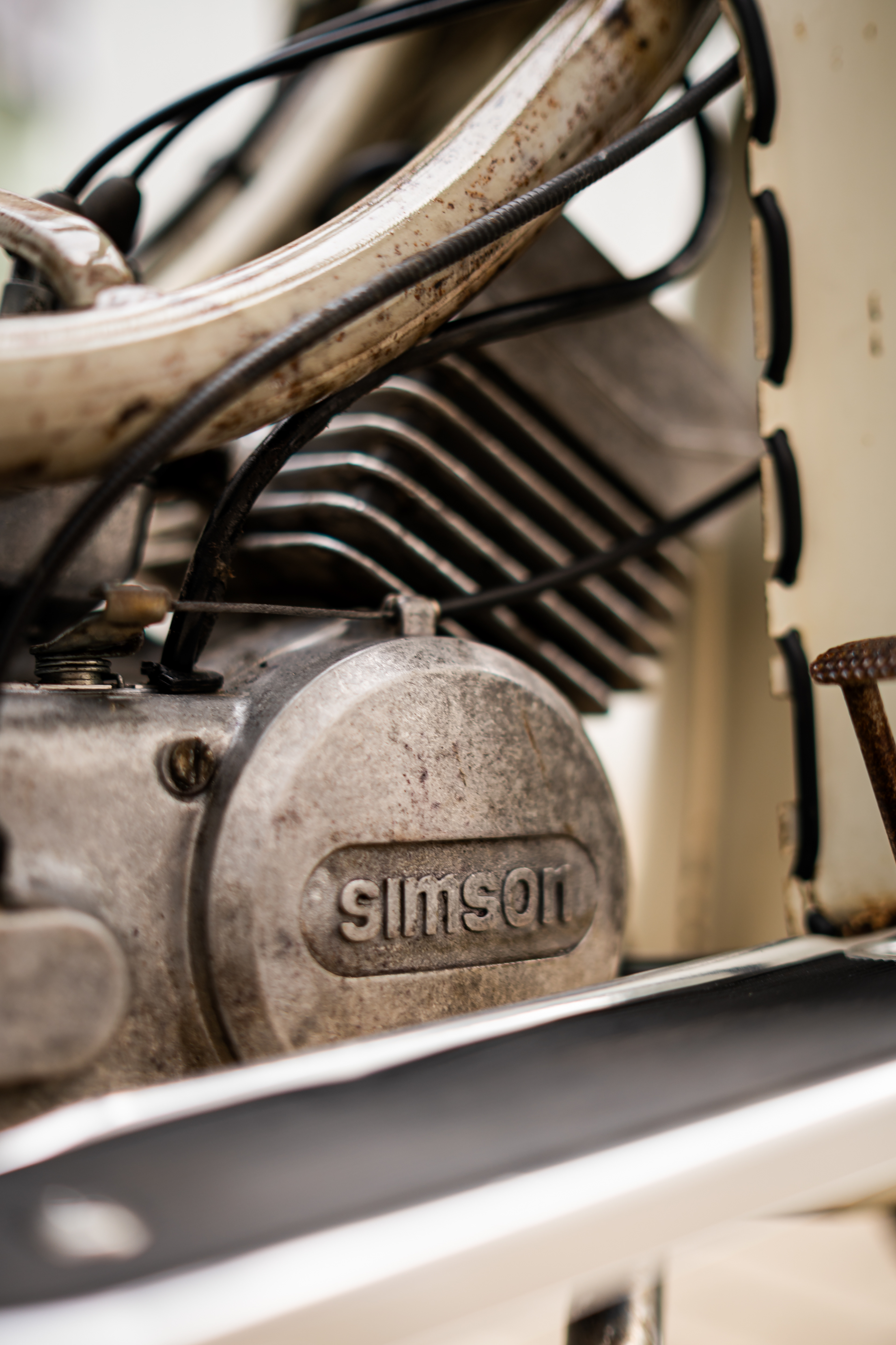Seitenansicht des offenen Motors einer Simson Schwalbe. Fokus auf den roten Öldeckel und die Patina. Technische KFZ-Detailfotografie in Biberach.