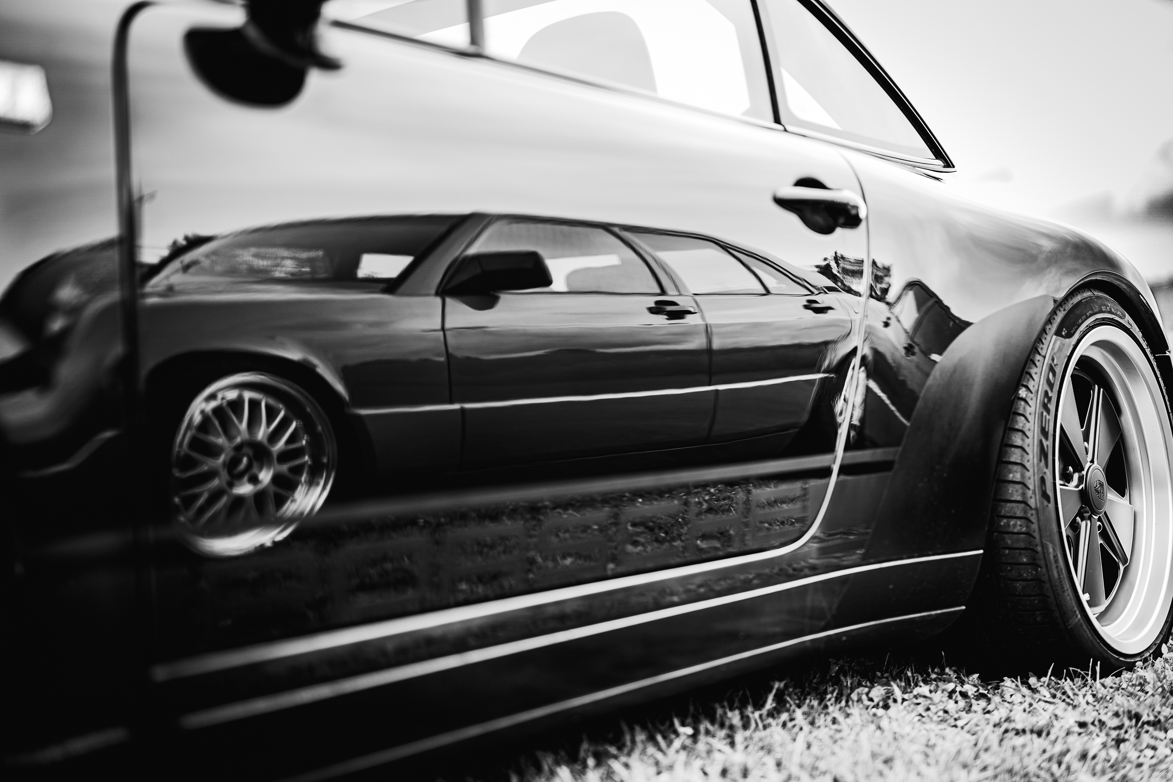 Klassischer schwarzer 1997 Porsche 993 Targa auf einer Wiese in Oggelshausen am Federsee während des Sonnenuntergangs. Hochwertige Automotive Art und professionelle Fahrzeugfotografie von MFuchsloch Fotografie & Videografie aus Oberschwaben.