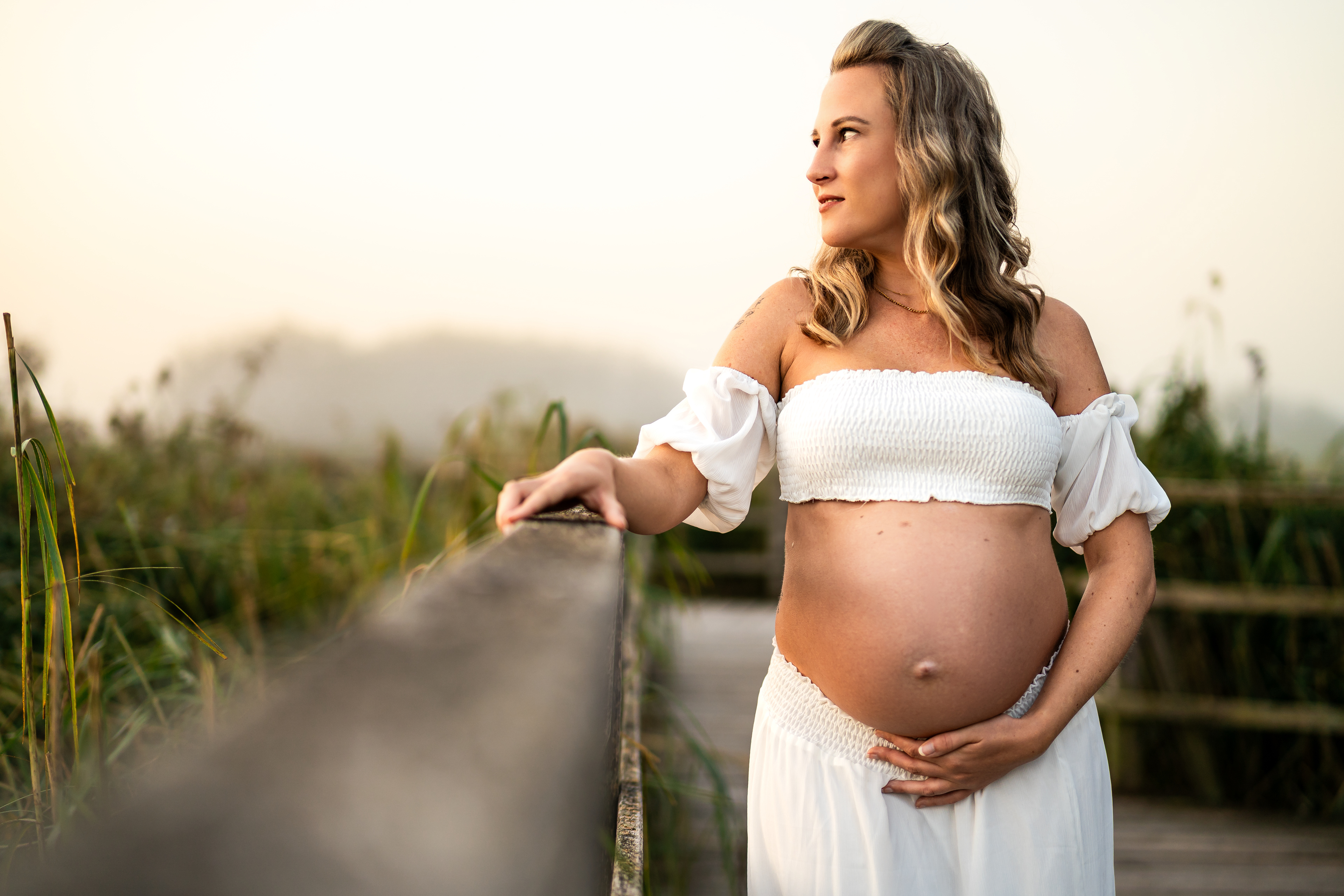 Natürliche Babybauchfotos am Federsee in Bad Buchau. Mfuchsloch Fotografie fängt die besondere Lichtstimmung am Steg für ungestellte Aufnahmen ein.