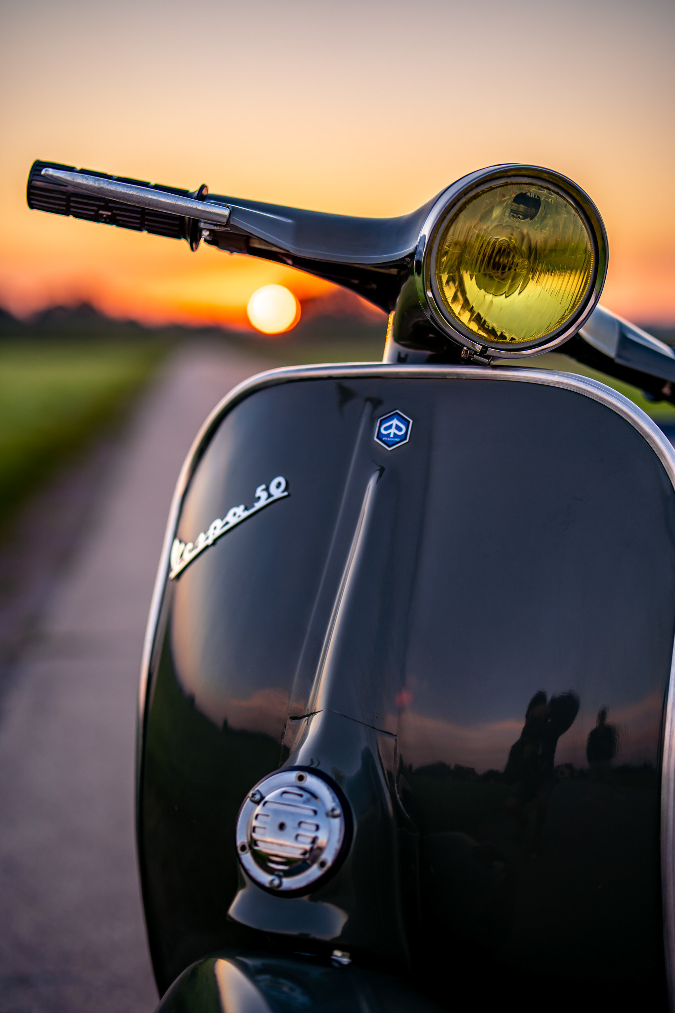 Klassische Vespa 50 Special in Aventurin Grün Metallic auf einem Feldweg mit Sonnenaufgang in Oggelshausen am Federsee während der Golden Hour. Professionelle Fahrzeugfotografie und Automotive Art von MFuchsloch Fotografie & Videografie aus Oberschwaben.
