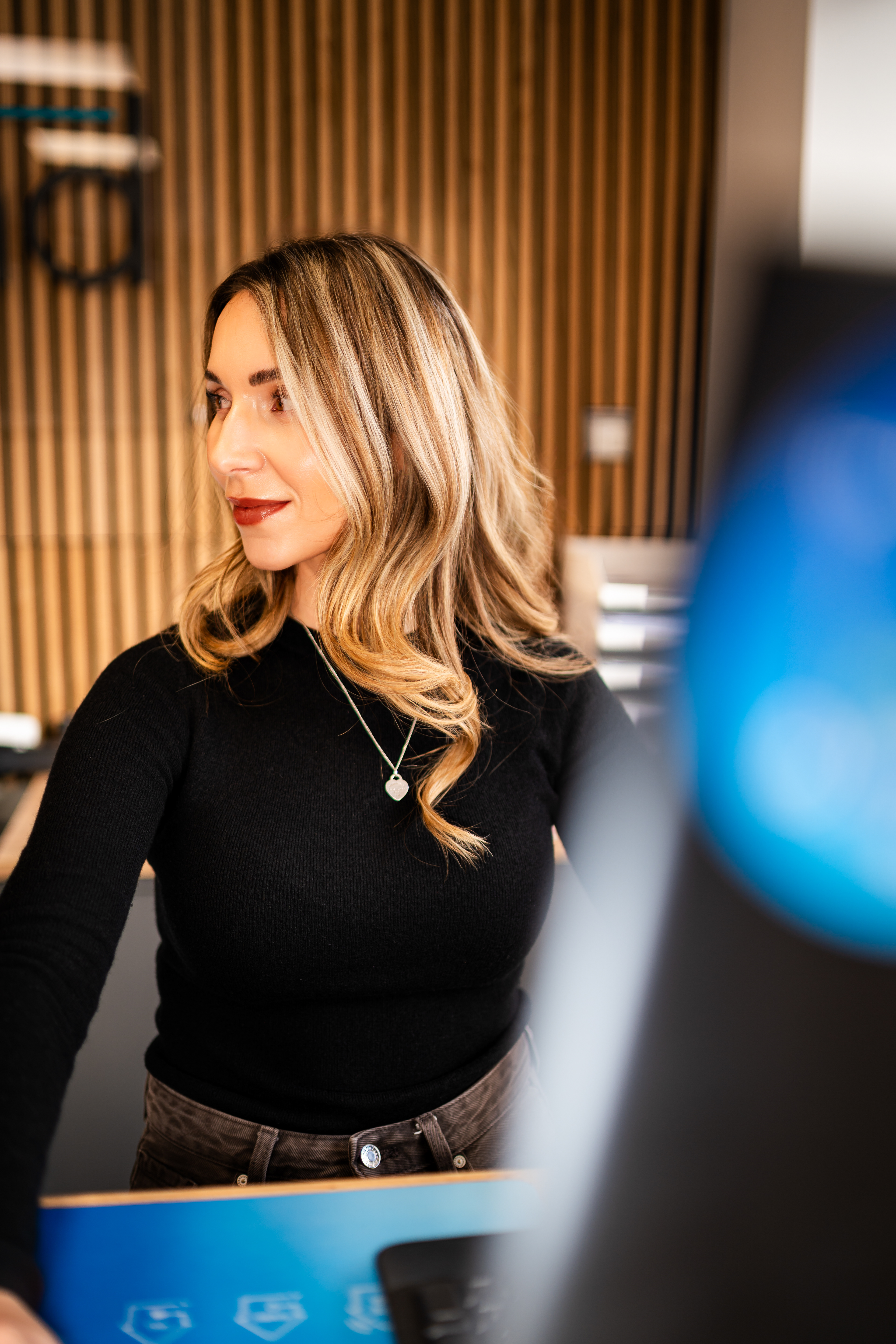 Sympathisches Mitarbeiterfoto vpn Mfuchsloch Fotografie Oggelshausen für Unternehmen in Bad Waldsee. Personal Branding & Firmenportraits vor moderner Holzoptik in Oberschwaben.