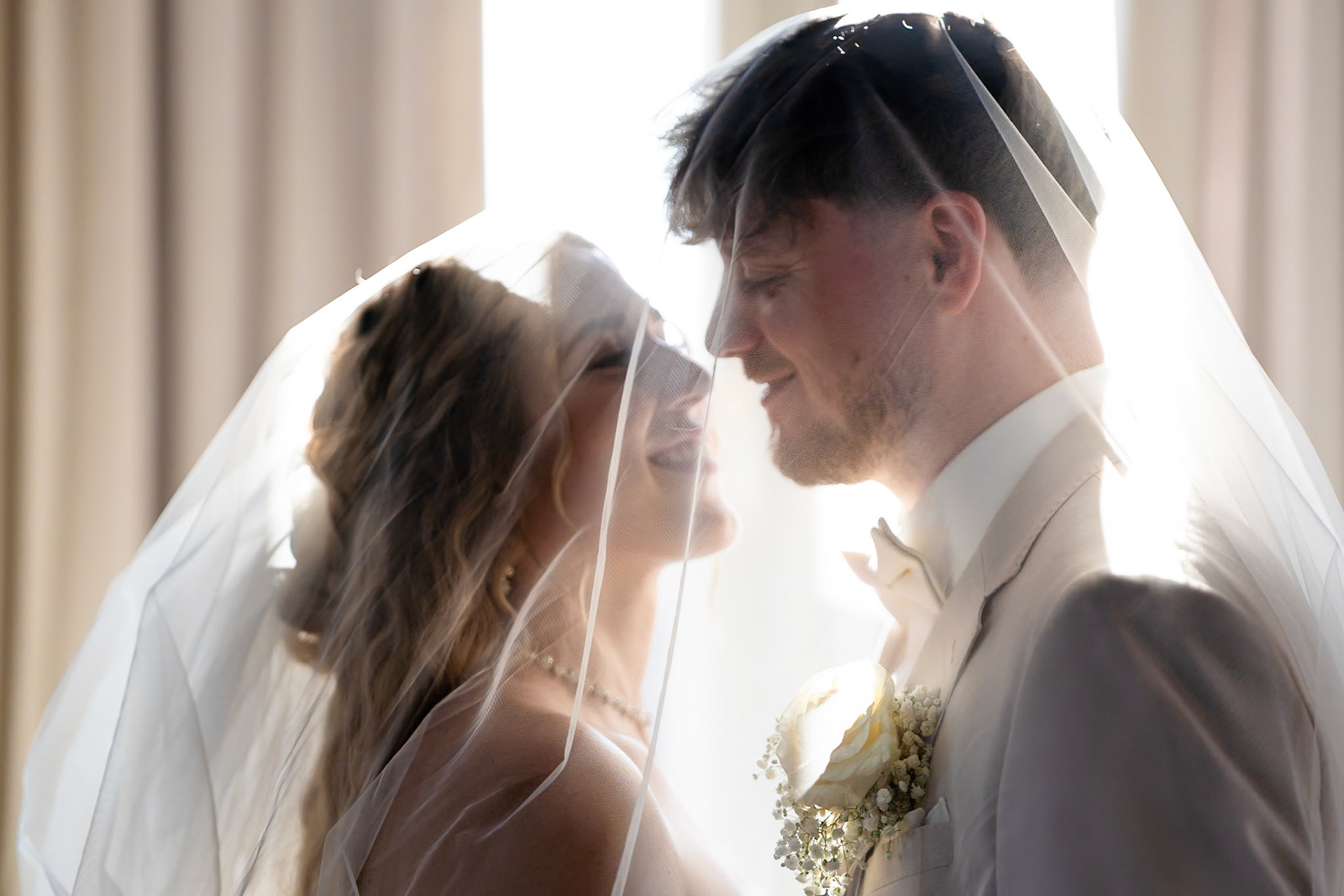 Romantisches Hochzeitsportrait von Braut und Bräutigam unter dem fließenden Brautschleier – MFuchsloch Hochzeitsfotografie & Videografie
