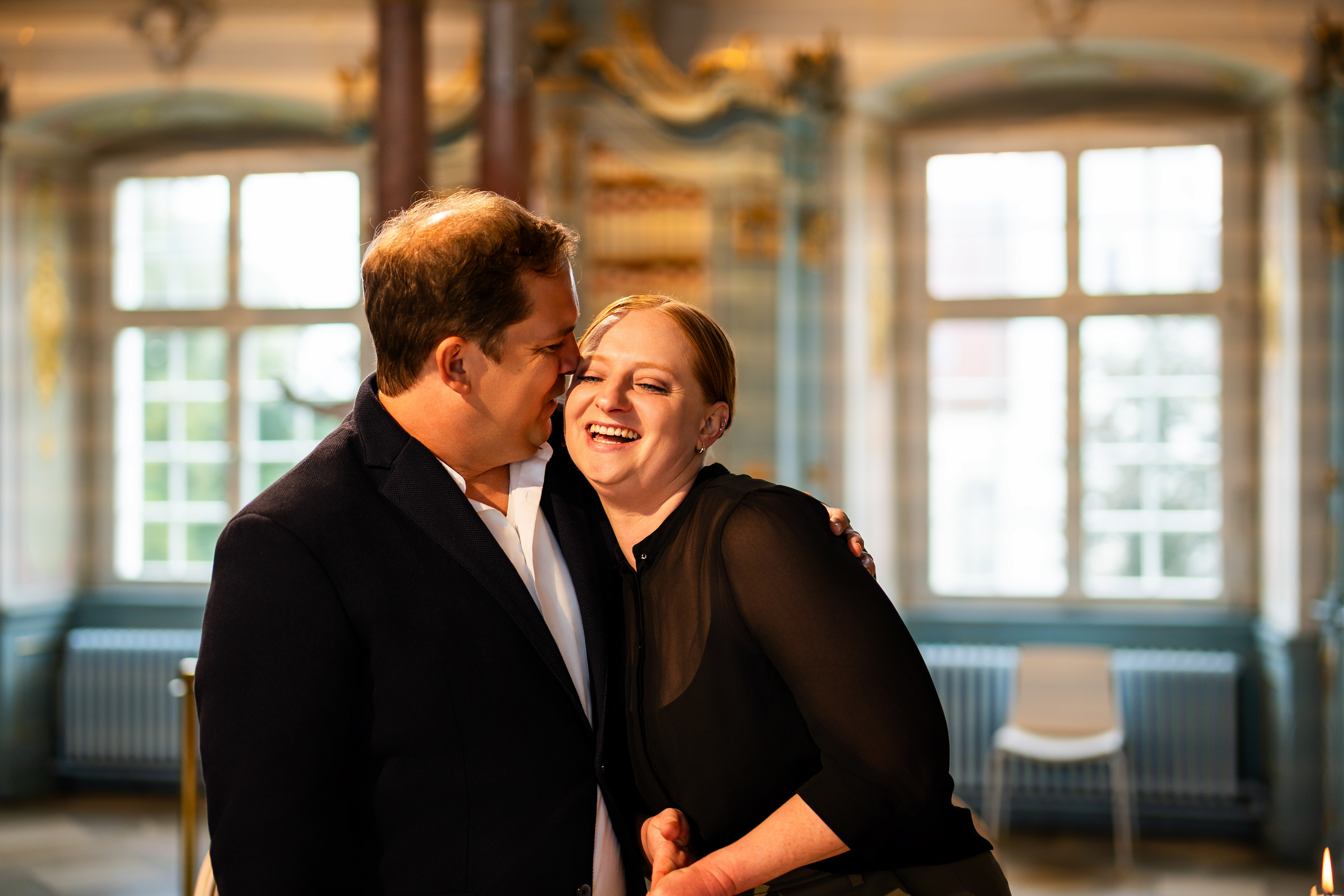 Brautpaar Händchen haltend während der standesamtlichen Trauung im barocken Bibliothekssaal des Klosters Schussenried. Aufgenommen von Hochzeitsfotograf MFUCHSLOCH.
