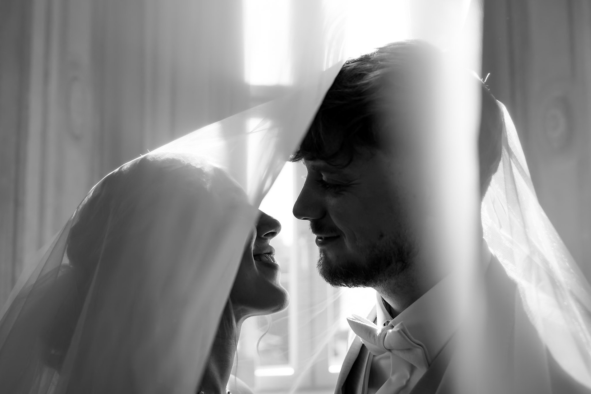 Romantisches Hochzeitsportrait von Braut und Bräutigam unter dem fließenden Brautschleier – MFuchsloch Hochzeitsfotografie & Videografie