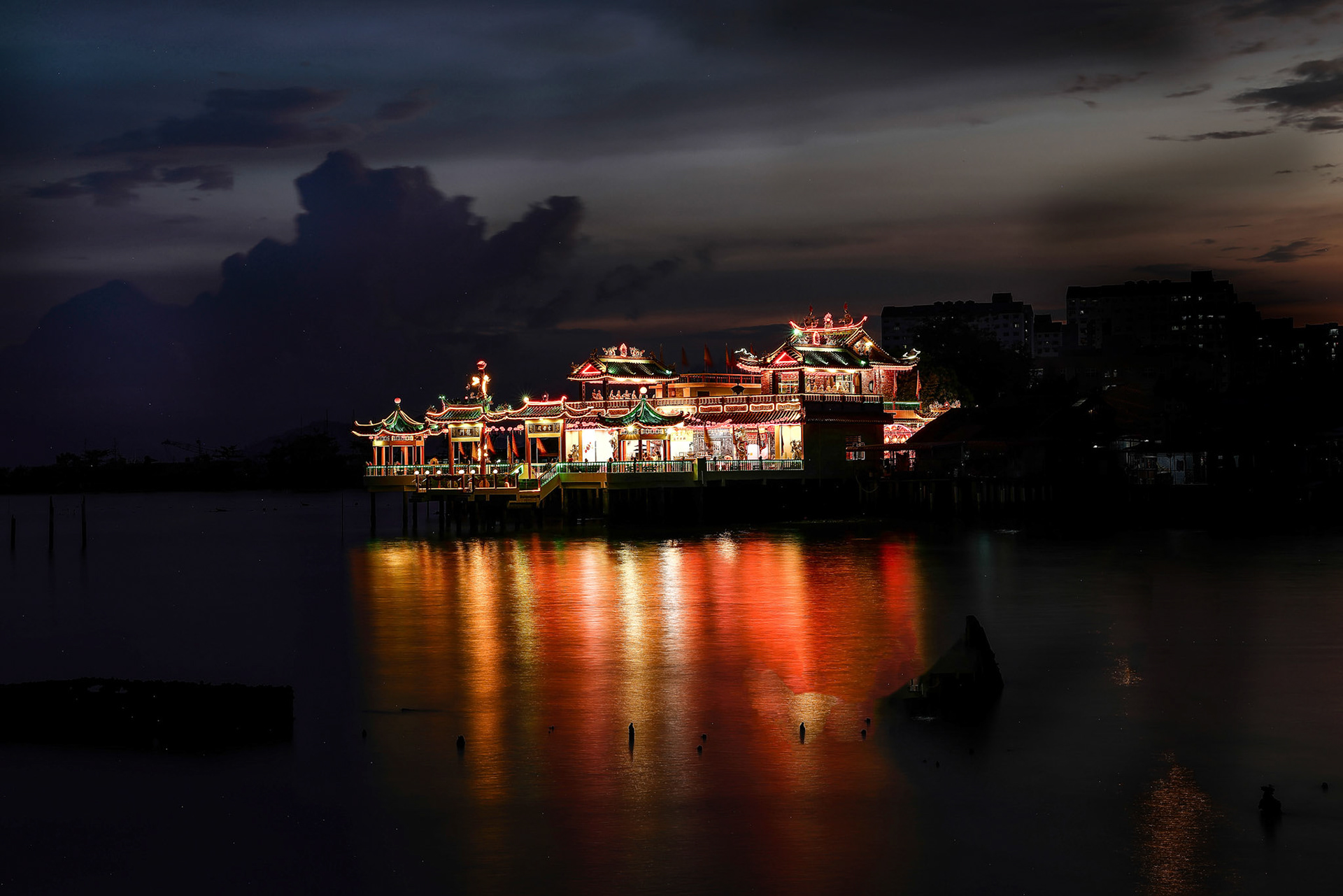Georgetown, Penang, Malaysia-February 03, 2022- The colourful lights of Hean Boo Thean also known as Floating Temple at sunset over water.