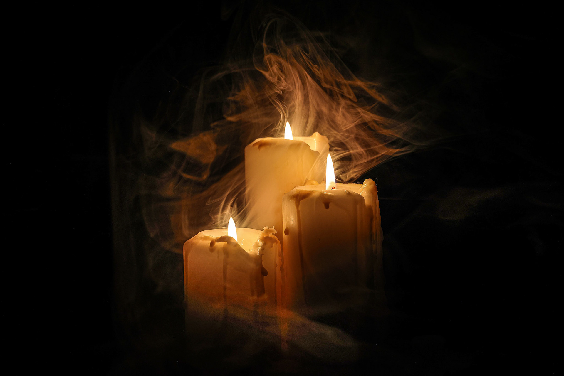 Lit candle flame through heavy smoke fog mist vapour flow twist beautiful mistic