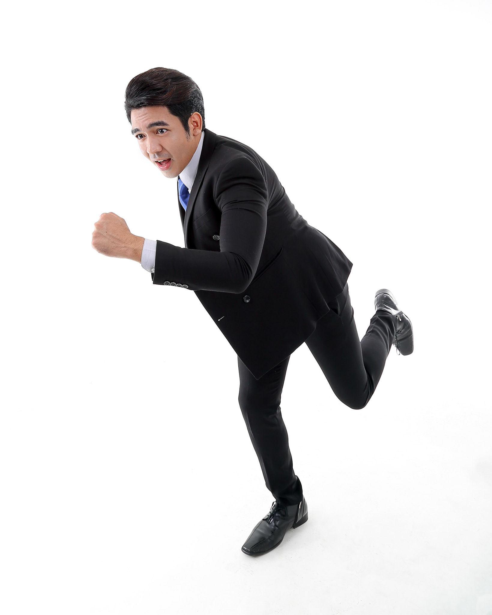 Southeast Asian young office business man wearing suit running at camera on white studio background