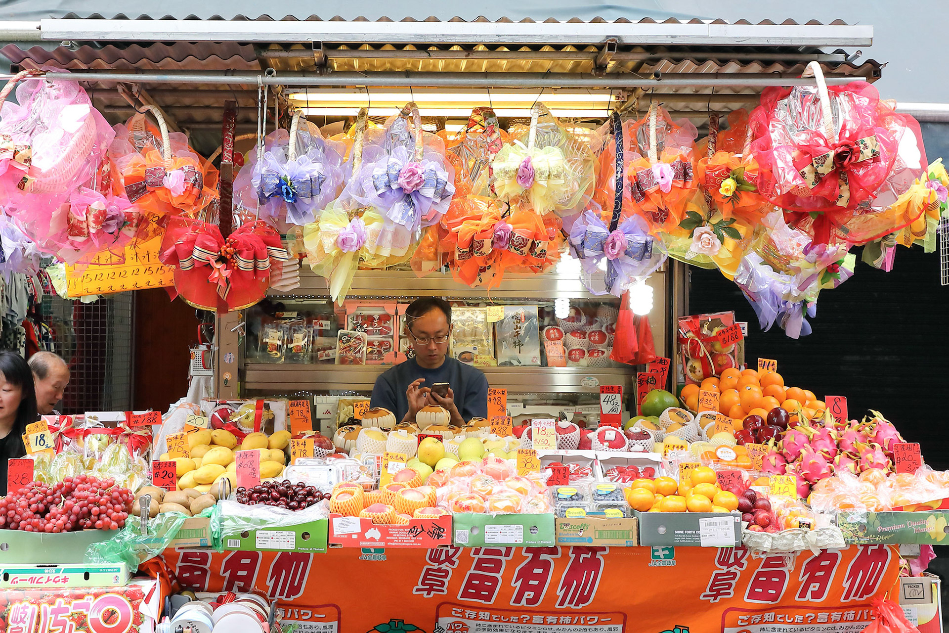 HONG KONG- FEBRUARY 19, 2018-Kawloon - Fruits vendors selling verity of fruits on street market stalls of Hong Kong,  the seasonal fruits are fresh and reasonably priced