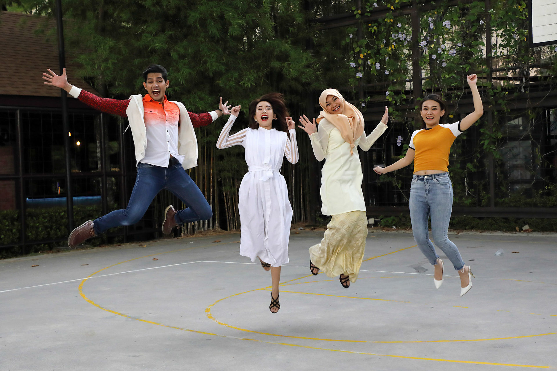 Group young asian chinese malay man woman wearing headscarf outdoor jump in the air happy exited